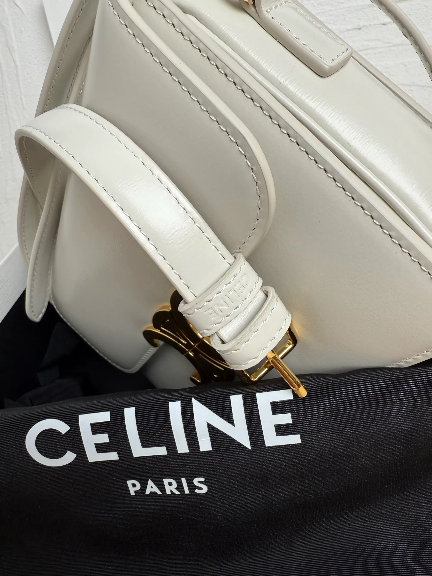 p1560. TEEN TRIOMPHE calfskin handbag This small TRIOMPHE handbag in satin calfskin comes with an adjustable leather shoulder strap and TRIOMPHE exclusive buckle TRIOMPHE brass lock interior zip pocket and interior flat pocket Adjustable leather shoulder strap Length 17 inches (42 cm) 7 X 6 X 2 inches (18.5 X 14 X 6 cm) No.: 188423