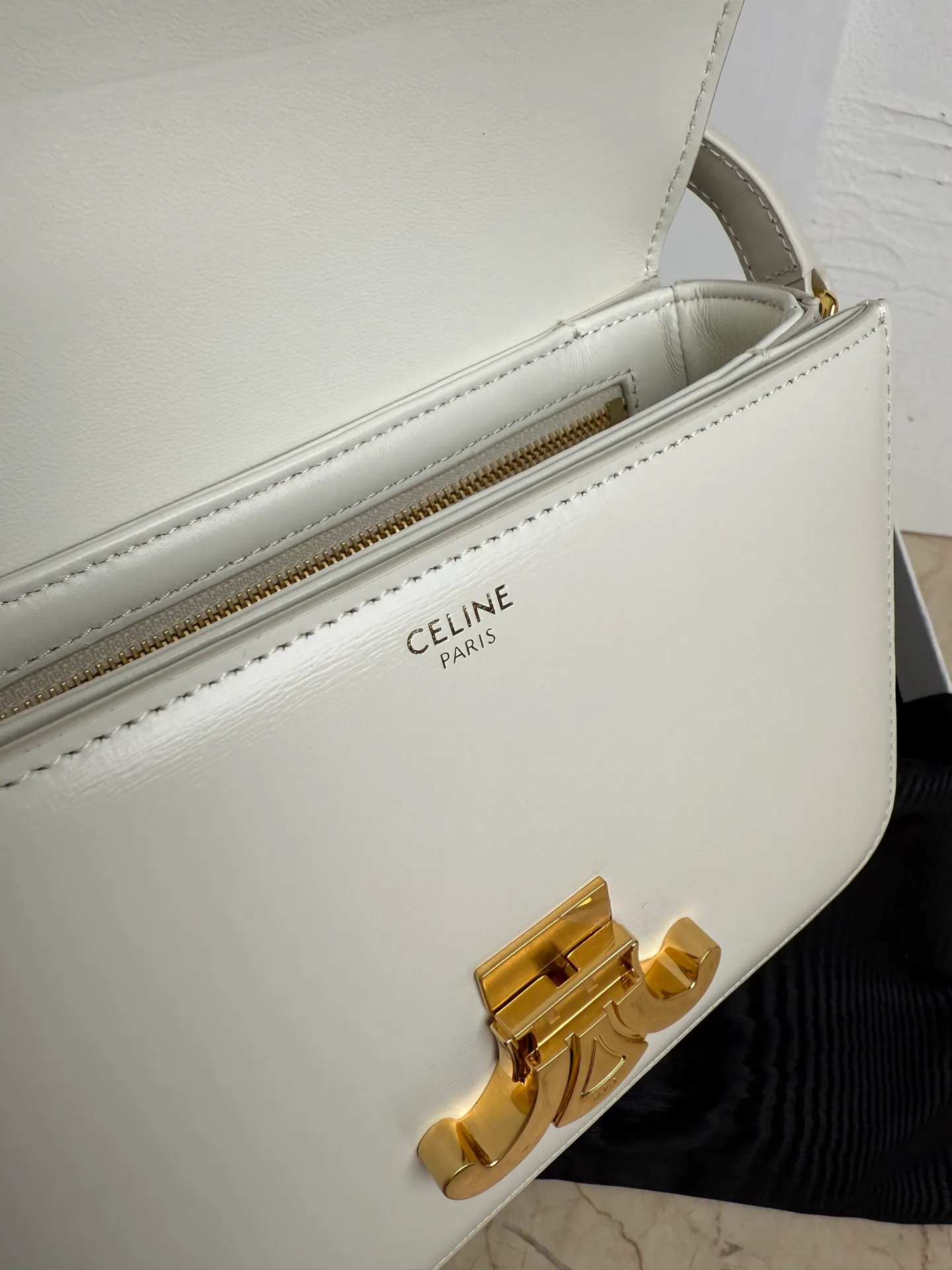p1560. TEEN TRIOMPHE calfskin handbag This small TRIOMPHE handbag in satin calfskin comes with an adjustable leather shoulder strap and TRIOMPHE exclusive buckle TRIOMPHE brass lock interior zip pocket and interior flat pocket Adjustable leather shoulder strap Length 17 inches (42 cm) 7 X 6 X 2 inches (18.5 X 14 X 6 cm) No.: 188423