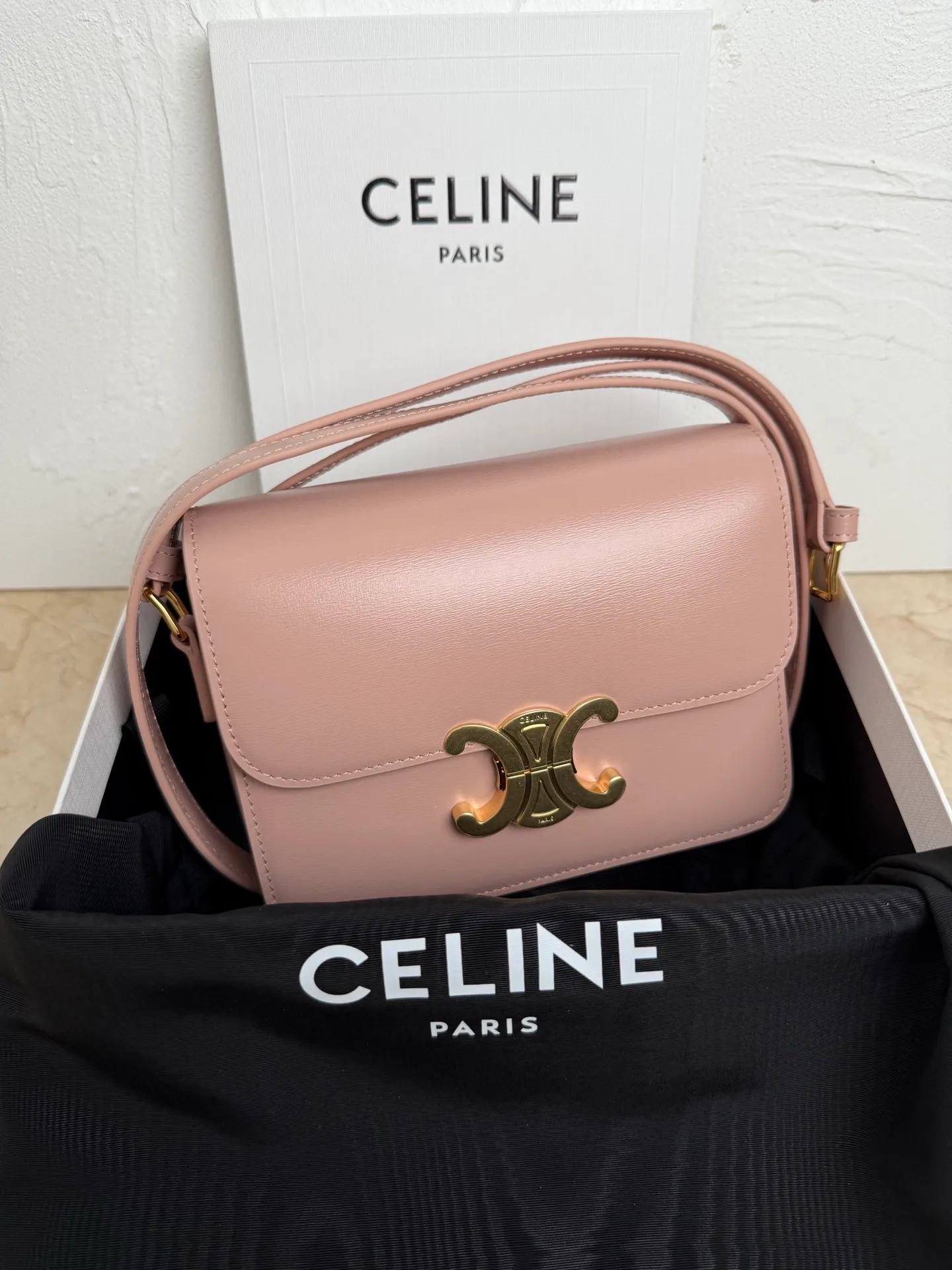 p1560. TEEN TRIOMPHE calfskin handbag This small TRIOMPHE handbag in satin calfskin comes with an adjustable leather shoulder strap and TRIOMPHE exclusive buckle TRIOMPHE brass lock interior zip pocket and interior flat pocket Adjustable leather shoulder strap Length 17 inches (42 cm) 7 X 6 X 2 inches (18.5 X 14 X 6 cm) No.: 188423