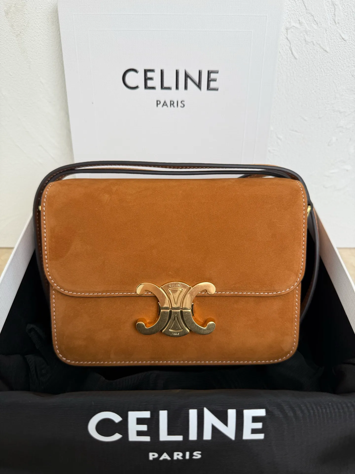 p1560. TEEN TRIOMPHE calfskin handbag This small TRIOMPHE handbag in satin calfskin comes with an adjustable leather shoulder strap and TRIOMPHE exclusive buckle TRIOMPHE brass lock interior zip pocket and interior flat pocket Adjustable leather shoulder strap Length 17 inches (42 cm) 7 X 6 X 2 inches (18.5 X 14 X 6 cm) No.: 188423