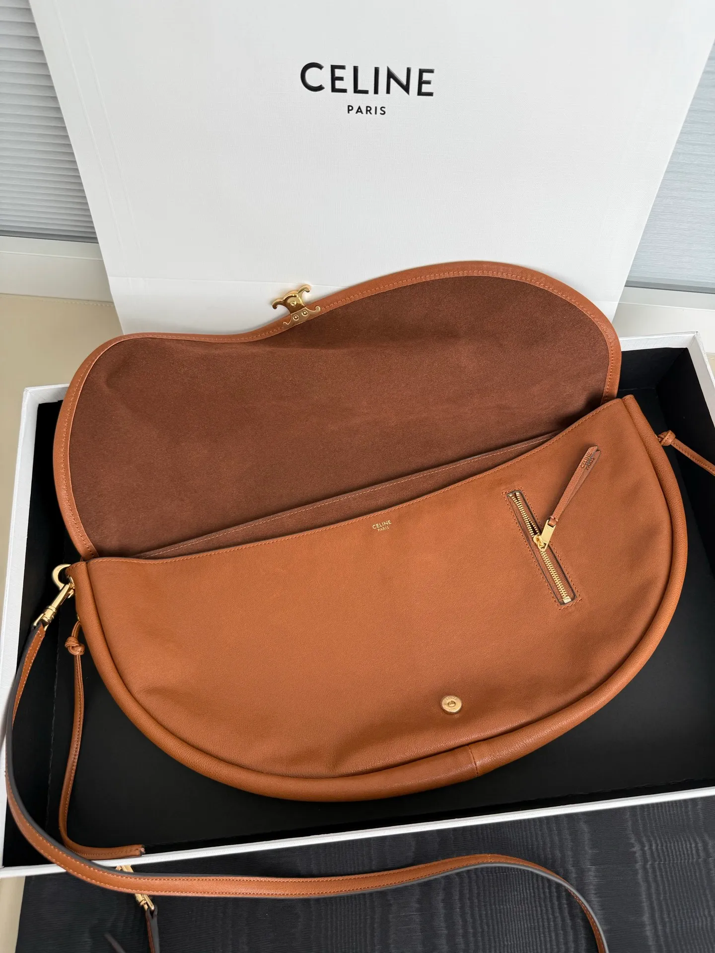 900. Soft Triomphe Halfmoon bag is fashionable✨ CELINE 26SPRING half-moon bag~ Fashionable and special-shaped bag. Large capacity can be used under armpit & one shoulder [kiss an R] I like the shiny leather. The material is shiny lambskin. It is quite light and has a minimalist and neat silhouette. It is fashionable in autumn and winter and can be pinched by the handle✨ Size: 46×19×10 Model: 124142