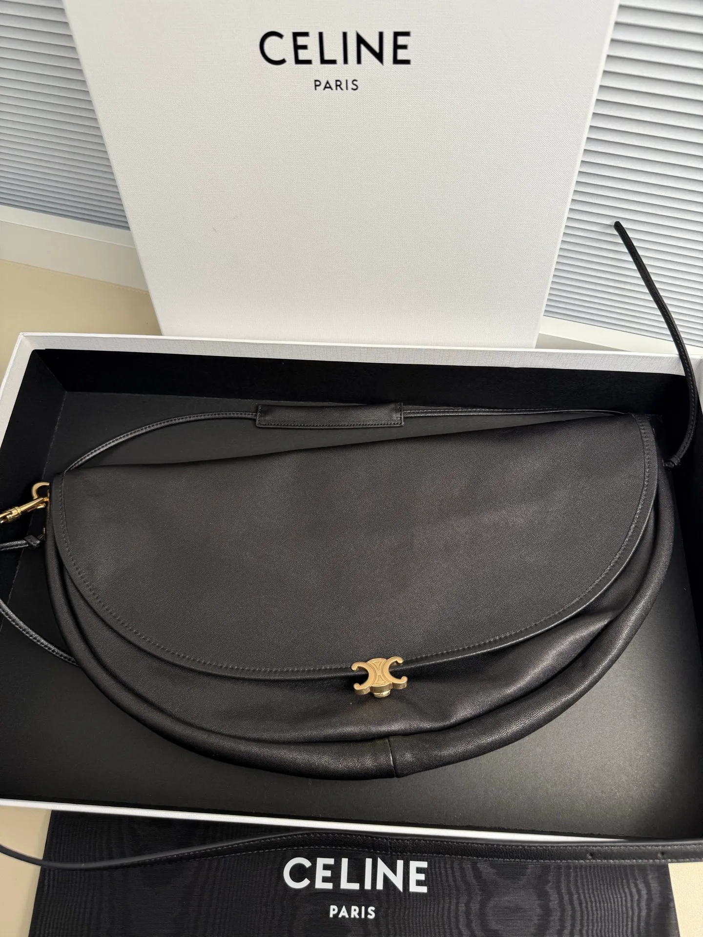 p1800. Soft Triomphe Halfmoon bag is fashionable✨ CELINE 26SPRING half-moon bag~ Fashionable and special-shaped bag. Large capacity can be used under armpit & one shoulder [kiss an R] I like the shiny leather. The material is shiny lambskin. It is quite light and has a minimalist and neat silhouette. It is fashionable in autumn and winter and can be pinched by the handle✨ Size: 46×19×10 Model: 124142