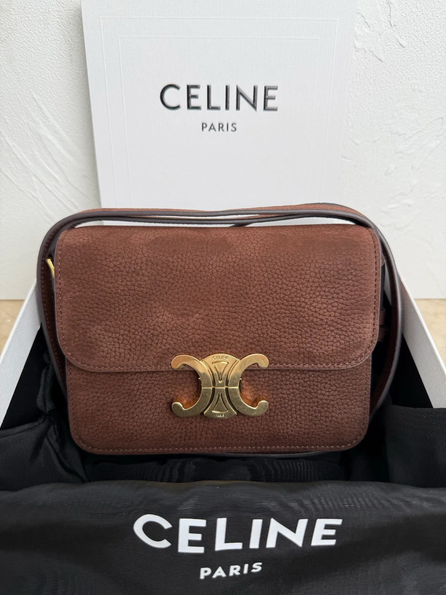 p1560. TEEN TRIOMPHE calfskin handbag This small TRIOMPHE handbag in satin calfskin comes with an adjustable leather shoulder strap and TRIOMPHE exclusive buckle TRIOMPHE brass lock interior zip pocket and interior flat pocket Adjustable leather shoulder strap Length 17 inches (42 cm) 7 X 6 X 2 inches (18.5 X 14 X 6 cm) No.: 188423
