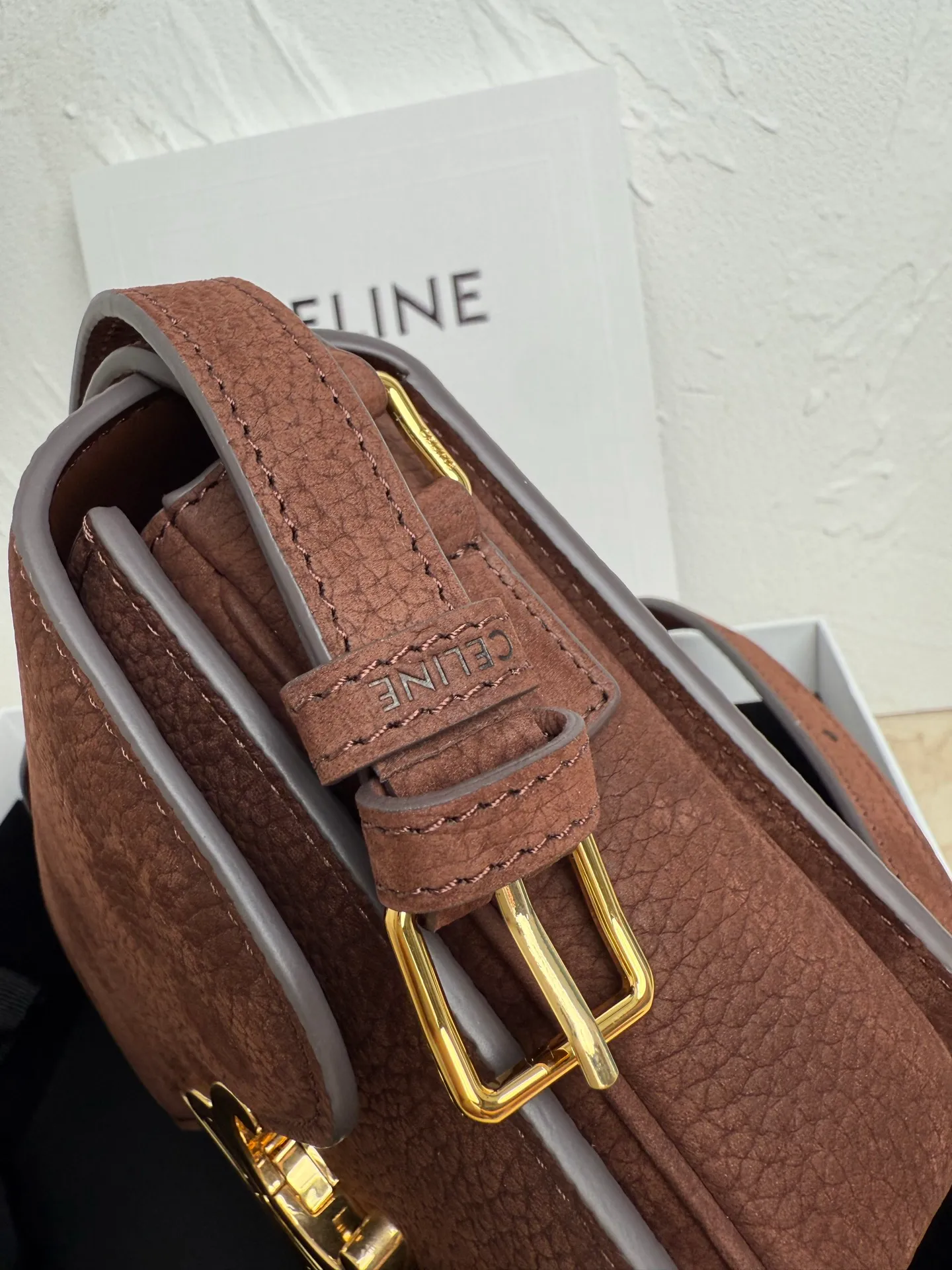 p1560. TEEN TRIOMPHE calfskin handbag This small TRIOMPHE handbag in satin calfskin comes with an adjustable leather shoulder strap and TRIOMPHE exclusive buckle TRIOMPHE brass lock interior zip pocket and interior flat pocket Adjustable leather shoulder strap Length 17 inches (42 cm) 7 X 6 X 2 inches (18.5 X 14 X 6 cm) No.: 188423