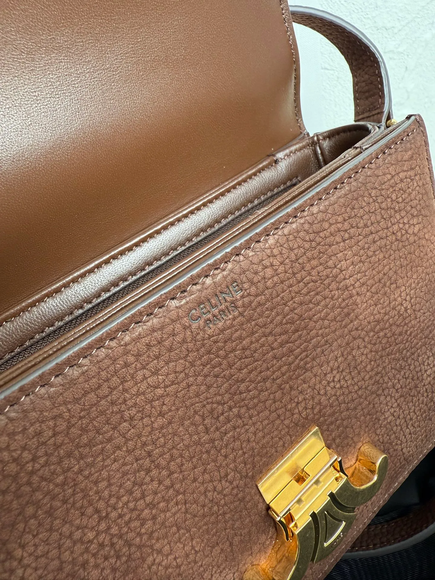 p1560. TEEN TRIOMPHE calfskin handbag This small TRIOMPHE handbag in satin calfskin comes with an adjustable leather shoulder strap and TRIOMPHE exclusive buckle TRIOMPHE brass lock interior zip pocket and interior flat pocket Adjustable leather shoulder strap Length 17 inches (42 cm) 7 X 6 X 2 inches (18.5 X 14 X 6 cm) No.: 188423