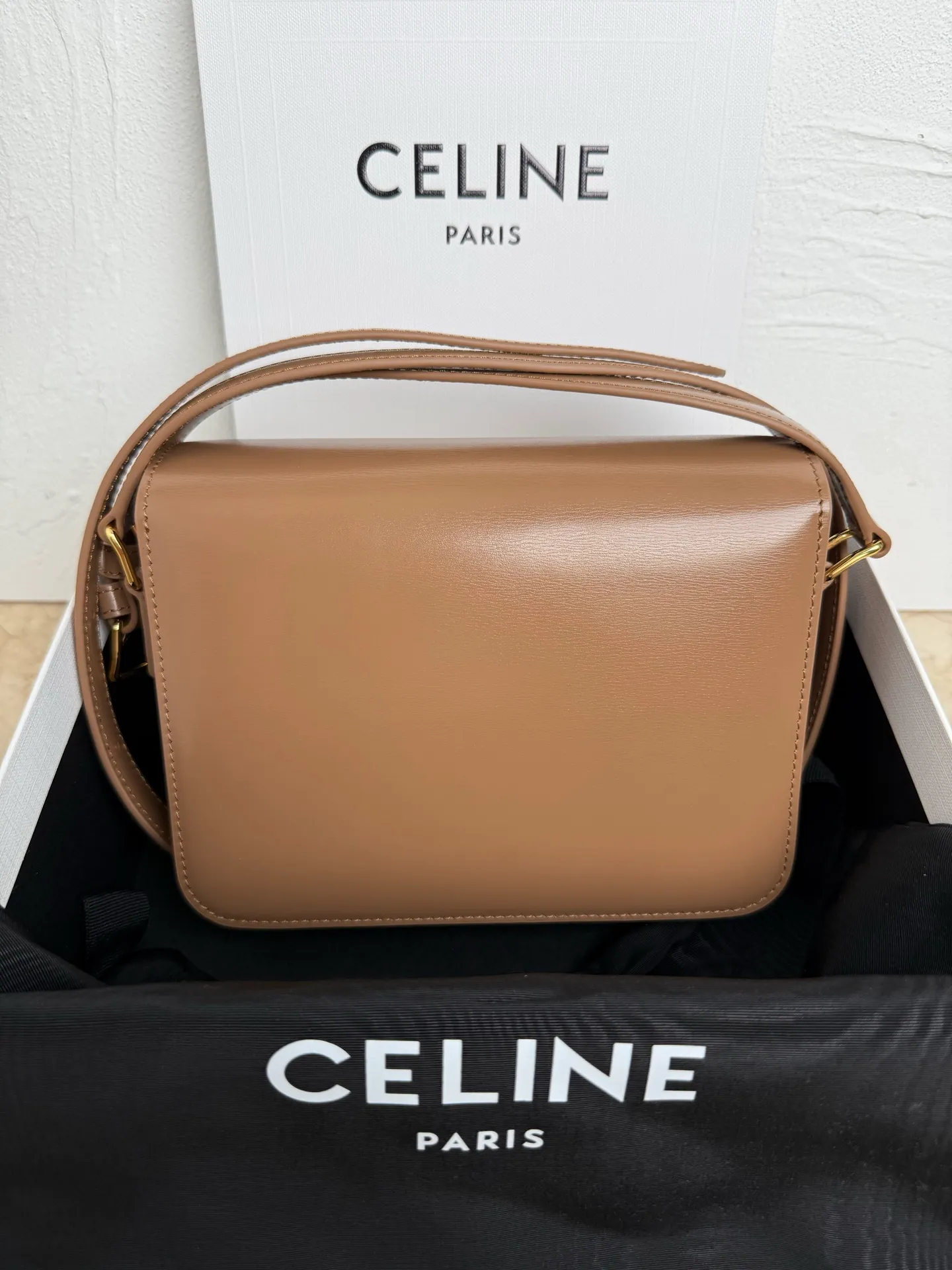 p1560. TEEN TRIOMPHE calfskin handbag This small TRIOMPHE handbag in satin calfskin comes with an adjustable leather shoulder strap and TRIOMPHE exclusive buckle TRIOMPHE brass lock interior zip pocket and interior flat pocket Adjustable leather shoulder strap Length 17 inches (42 cm) 7 X 6 X 2 inches (18.5 X 14 X 6 cm) No.: 188423