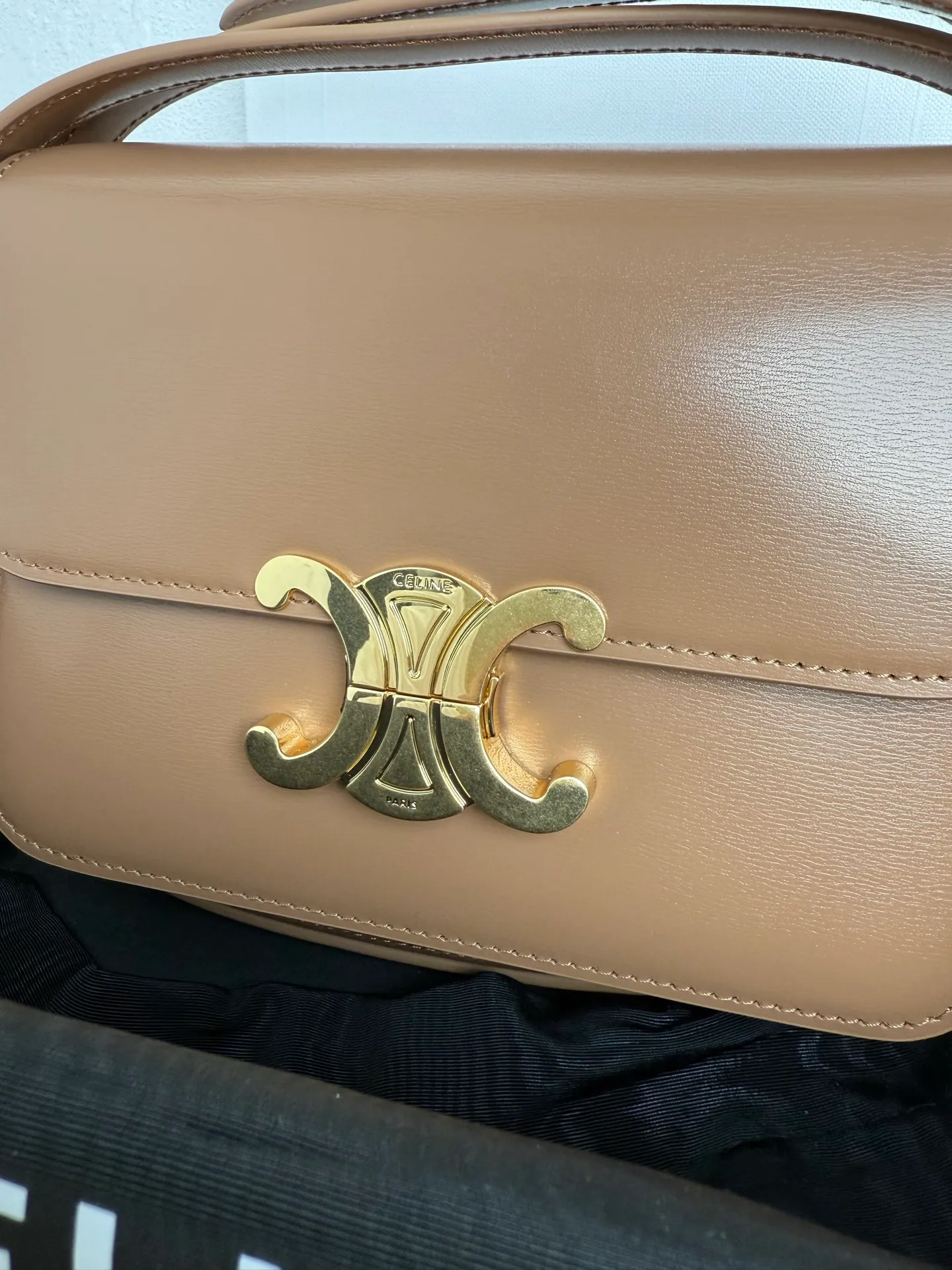 p1560. TEEN TRIOMPHE calfskin handbag This small TRIOMPHE handbag in satin calfskin comes with an adjustable leather shoulder strap and TRIOMPHE exclusive buckle TRIOMPHE brass lock interior zip pocket and interior flat pocket Adjustable leather shoulder strap Length 17 inches (42 cm) 7 X 6 X 2 inches (18.5 X 14 X 6 cm) No.: 188423