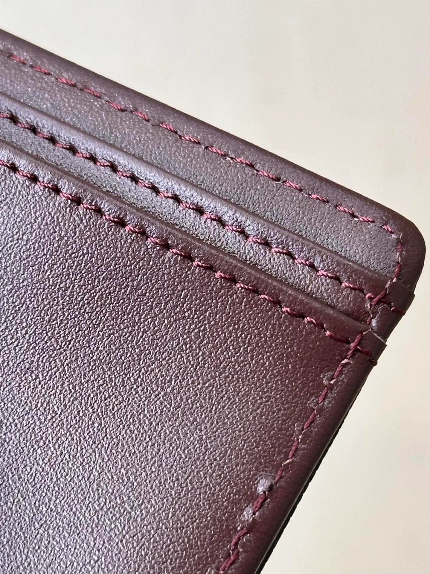 96066 The interior is made of burgundy calfskin. The leather has its own luster, and the texture is clear and delicate. It has various card slots on the side and an anti-counterfeiting code design on the inside.