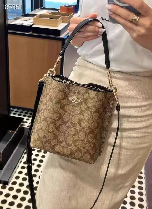 CA582, Coach's latest Mollie series bucket bag, small size, made of old PVC material and cowhide material. It is equipped with two detachable shoulder straps, long and short, which can be carried by hand or cross-body. There is a zipper compartment in the middle of the bag, which has good accommodation. The flat body of the bag is more comfortable on the upper body. Size:22*20*10cm