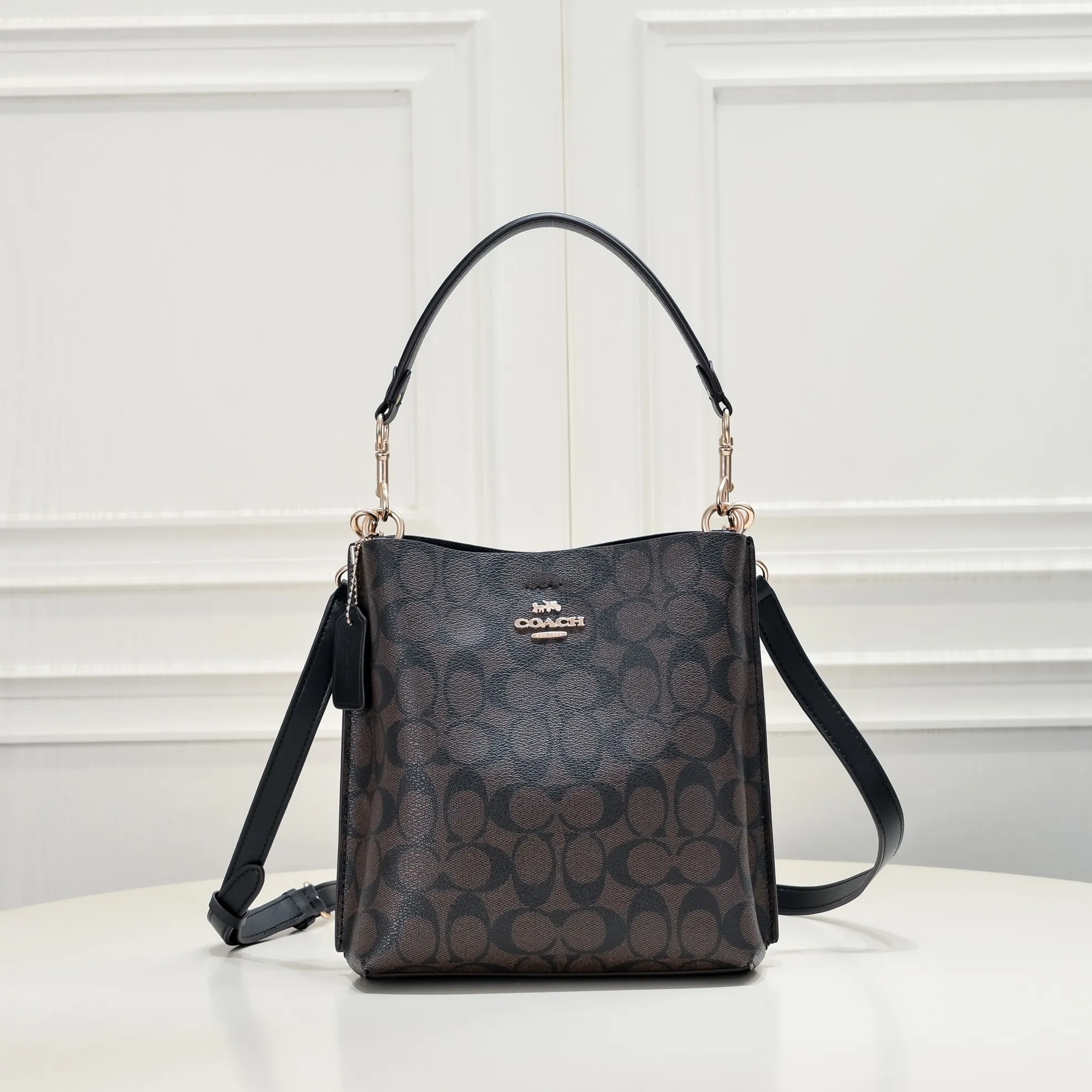 CA582, Coach's latest Mollie series bucket bag, small size, made of old PVC material and cowhide material. It is equipped with two detachable shoulder straps, long and short, which can be carried by hand or cross-body. There is a zipper compartment in the middle of the bag, which has good accommodation. The flat body of the bag is more comfortable on the upper body. Size:22*20*10cm