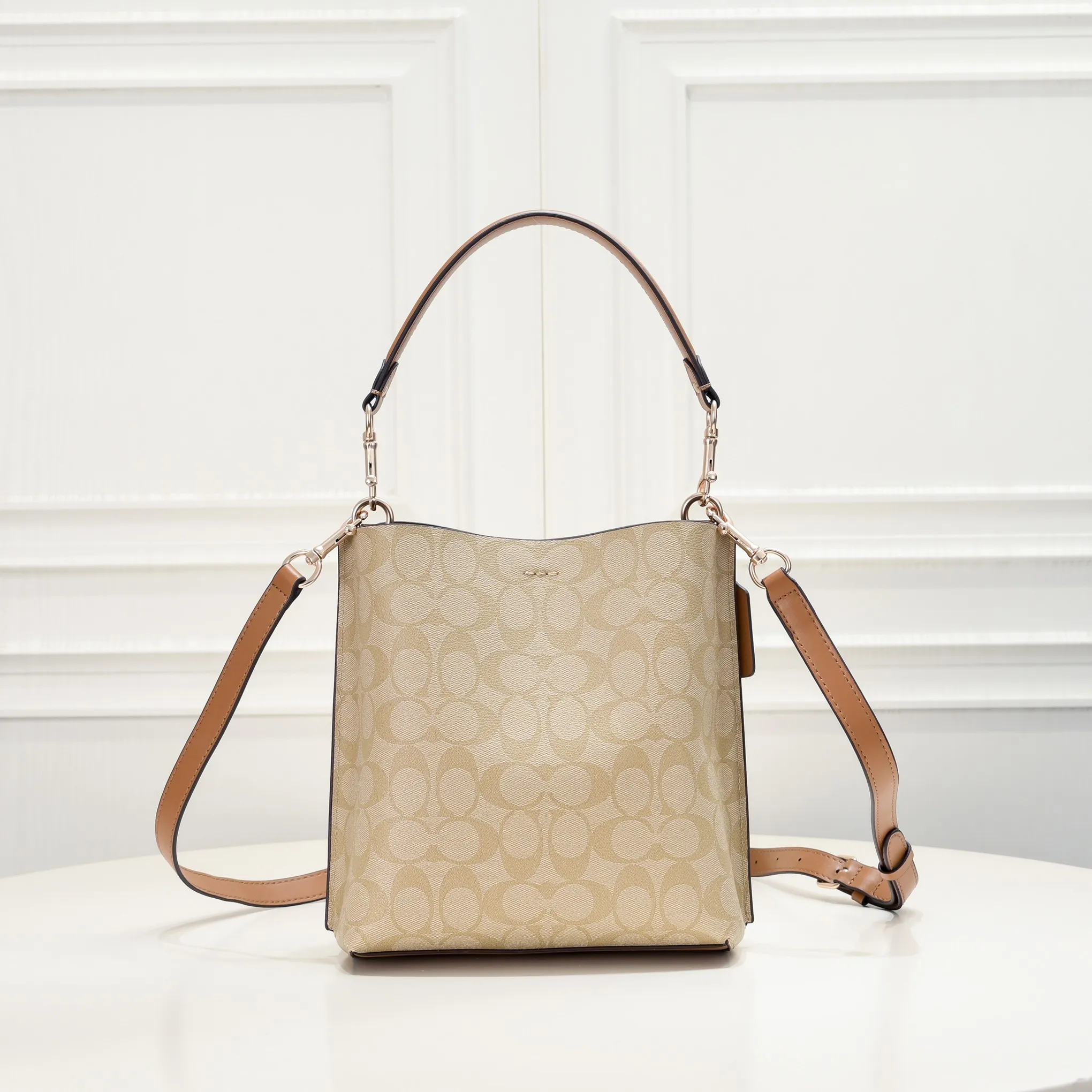 CA582, Coach's latest Mollie series bucket bag, small size, made of old PVC material and cowhide material. It is equipped with two detachable shoulder straps, long and short, which can be carried by hand or cross-body. There is a zipper compartment in the middle of the bag, which has good accommodation. The flat body of the bag is more comfortable on the upper body. Size:22*20*10cm