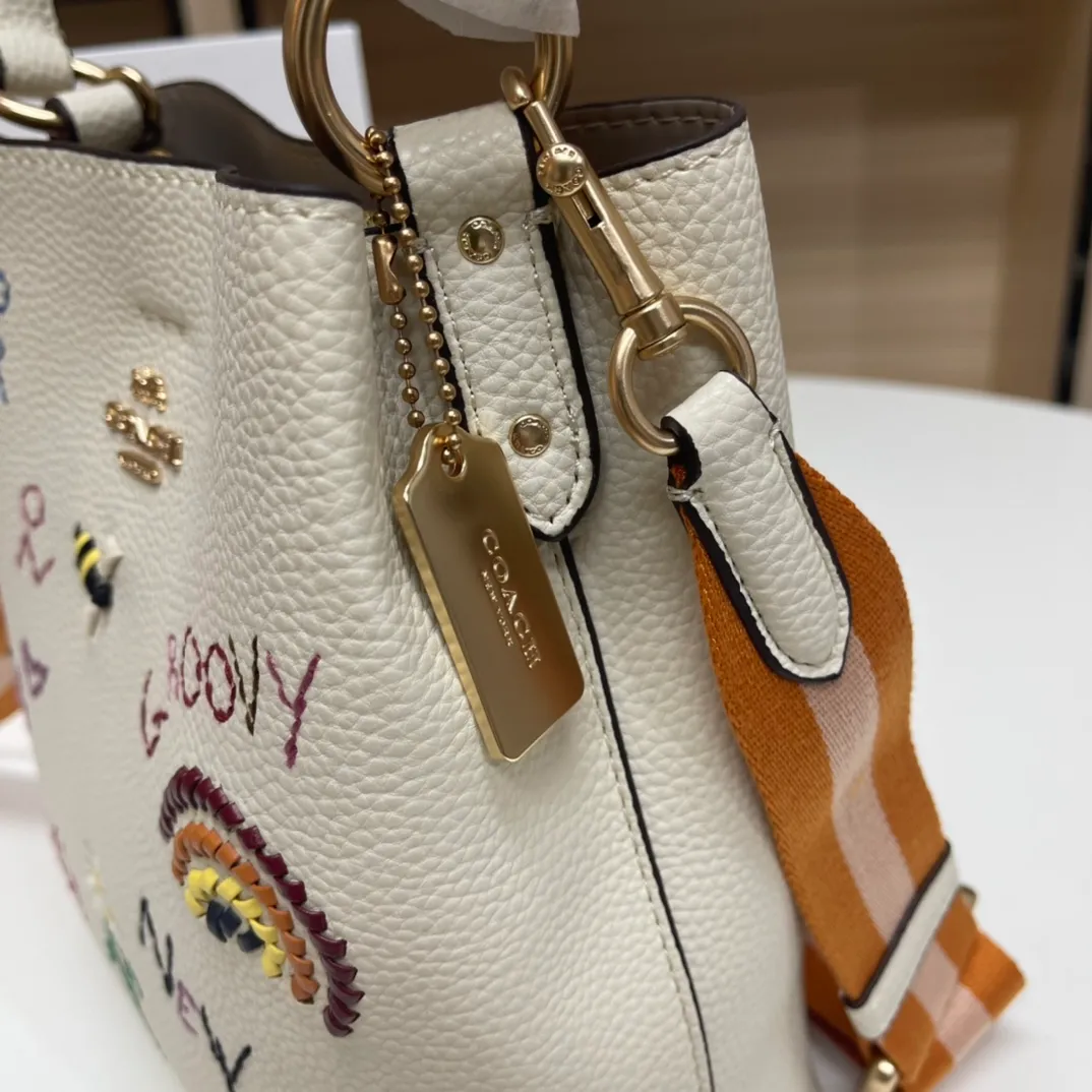 Batch 520💰coach/Coach new model, co-branded with Basquiat, the latest model, small embroidered woven bucket bag. 👑, with cloth shoulder straps and wrist straps, it can meet various travel matching needs. Full leather bag body, with first-layer cowhide 🌹Size 21x22X10.5