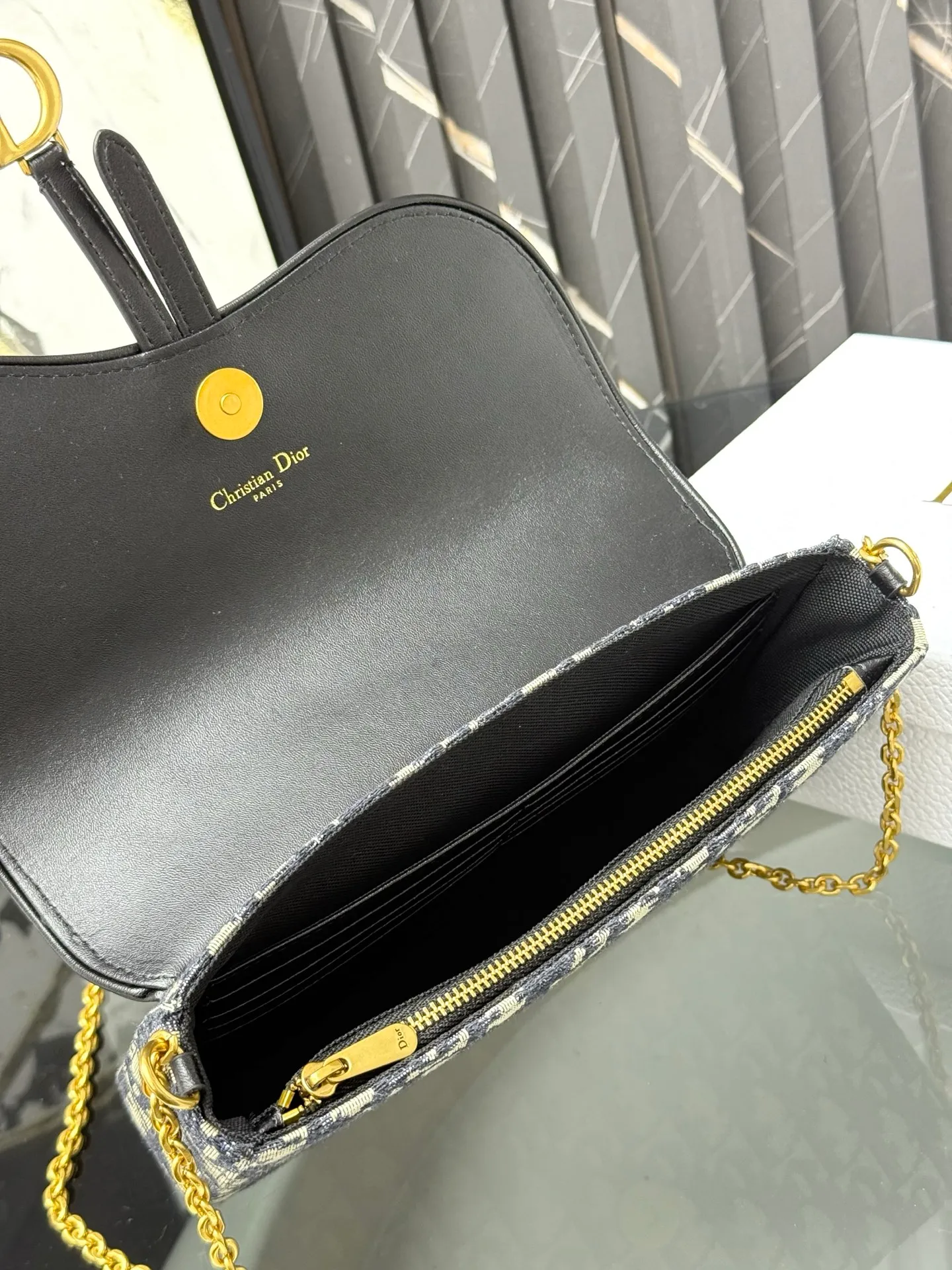 💰290💰 This saddle chain handbag has smooth and coordinated lines, making it a fashionable and practical item. Carefully crafted from blue Denim Dior Oblique jacquard fabric, the classic Dior pattern is reinterpreted with an irregular stonewash effect to highlight the fashionable style. It is paired with an asymmetric flap and a metal stirrup D-shaped pendant with antique gold finish. The spacious interior compartments can store a variety of daily essentials, and the chain makes it easy to carry on the shoulder or cross-body. Easily combines with other pieces from the saddle collection. Flap closure No.: S5907CTZQ_M928 Front stirrup D-shaped charm 1 compartment 6 card slots 1 slip pocket - No.: S5097 Dimensions: 21.5x12.5x3.7 cm (LxHxW) Can store 1 mobile phone, 1 card holder and lipstick Chain length: 118 cm Length from the top of the chain to the top of the bag: 57 cm
