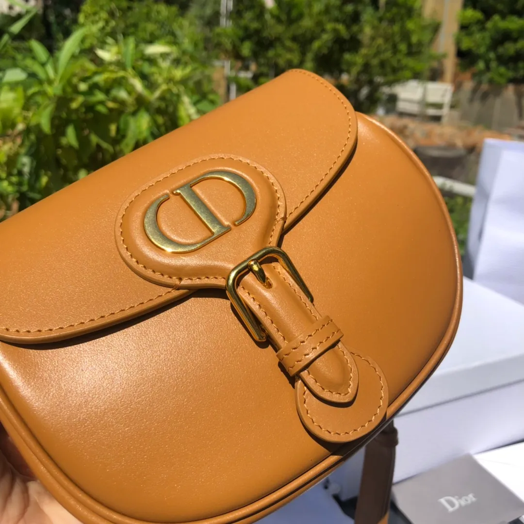 Top upgraded version💰1700 Small size: 18×14×5cm Dior’s new products are available through overseas channels! The Dior Bobby bag is designed as a shoulder bag, highlighting its elegant silhouette and harmonious proportions. This small bag is crafted from camel glossy calfskin and accented with antiqued gold hardware for added style. The interior is designed with suede leather, which is soft and rich in texture. With a detachable and adjustable shoulder strap embellished with a military-style buckle, it can be worn on the shoulder, cross-body or handheld.