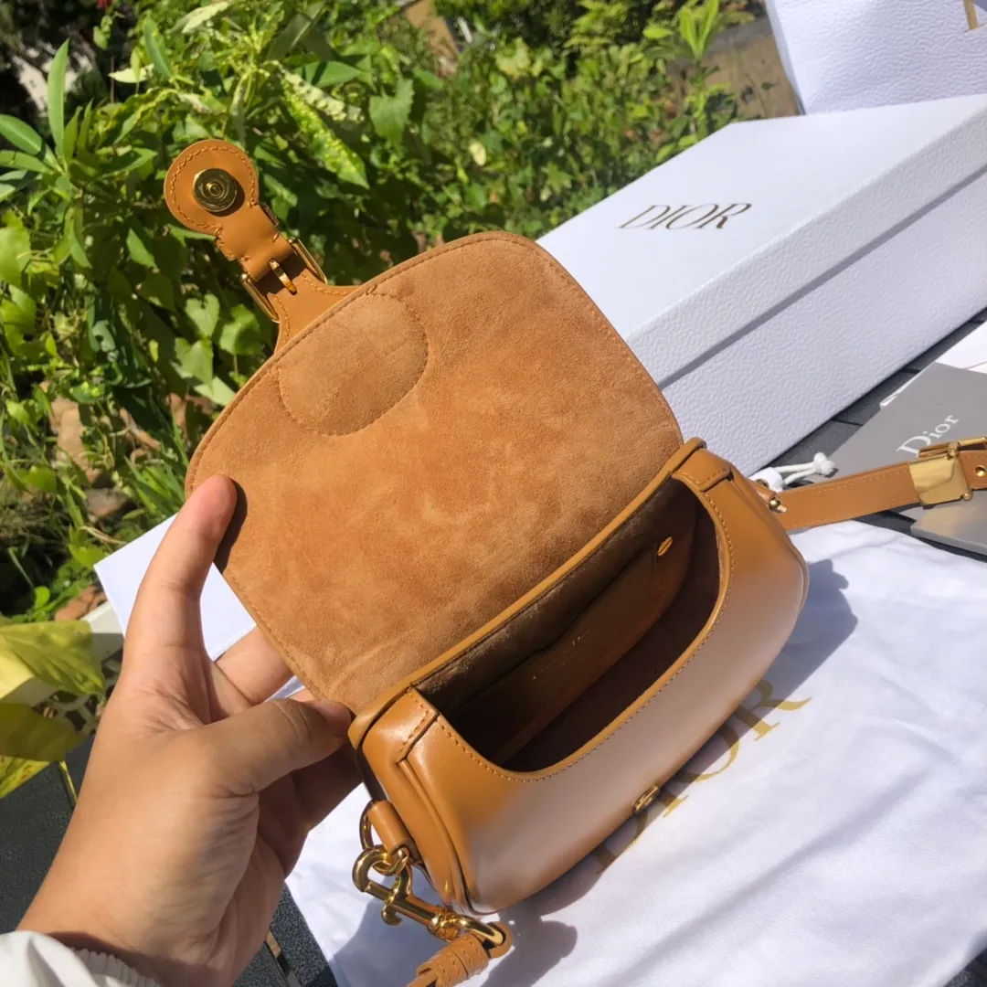 Top upgraded version💰1700 Small size: 18×14×5cm Dior’s new products are available through overseas channels! The Dior Bobby bag is designed as a shoulder bag, highlighting its elegant silhouette and harmonious proportions. This small bag is crafted from camel glossy calfskin and accented with antiqued gold hardware for added style. The interior is designed with suede leather, which is soft and rich in texture. With a detachable and adjustable shoulder strap embellished with a military-style buckle, it can be worn on the shoulder, cross-body or handheld.