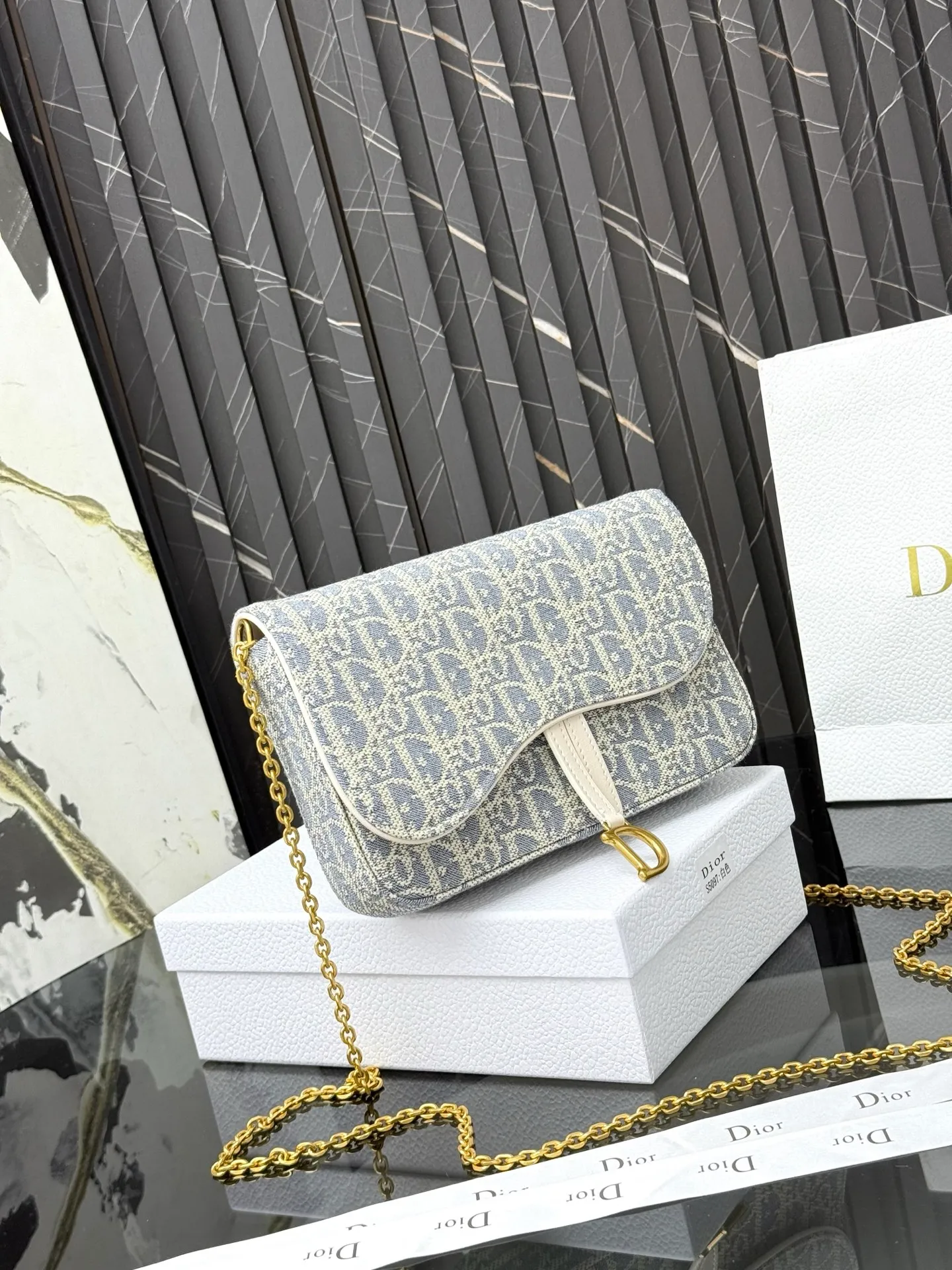 💰290💰 This saddle chain handbag has smooth and coordinated lines, making it a fashionable and practical item. Carefully crafted from blue Denim Dior Oblique jacquard fabric, the classic Dior pattern is reinterpreted with an irregular stonewash effect to highlight the fashionable style. It is paired with an asymmetric flap and a metal stirrup D-shaped pendant with antique gold finish. The spacious interior compartments can store a variety of daily essentials, and the chain makes it easy to carry on the shoulder or cross-body. Easily combines with other pieces from the saddle collection. Flap closure No.: S5907CTZQ_M928 Front stirrup D-shaped charm 1 compartment 6 card slots 1 slip pocket - No.: S5097 Dimensions: 21.5x12.5x3.7 cm (LxHxW) Can store 1 mobile phone, 1 card holder and lipstick Chain length: 118 cm Length from the top of the chain to the top of the bag: 57 cm