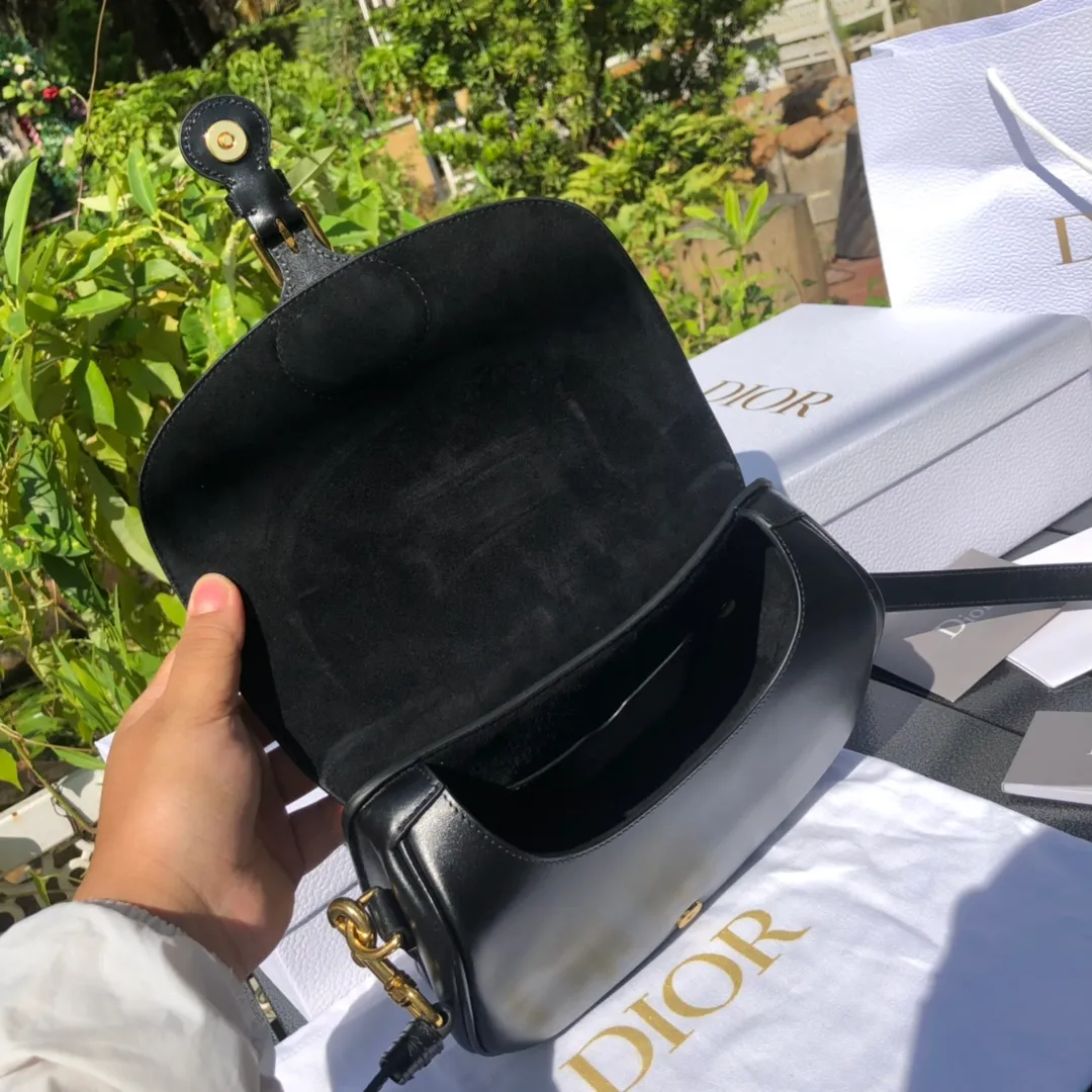 Top upgraded version 💰1760 Medium size: 22×17×6cm Dior Bobby’s new product is available from overseas channels! The new Dior saddle bag has finally arrived❗️This model is carefully made of black glossy cow leather, with a suede interior design, which is soft and rich in texture. It has a flip-top magnetic buckle design and a "CD" buckle on the front as decoration. With a detachable and adjustable shoulder strap embellished with a military-style buckle, it can be worn on the shoulder, cross-body or handheld.