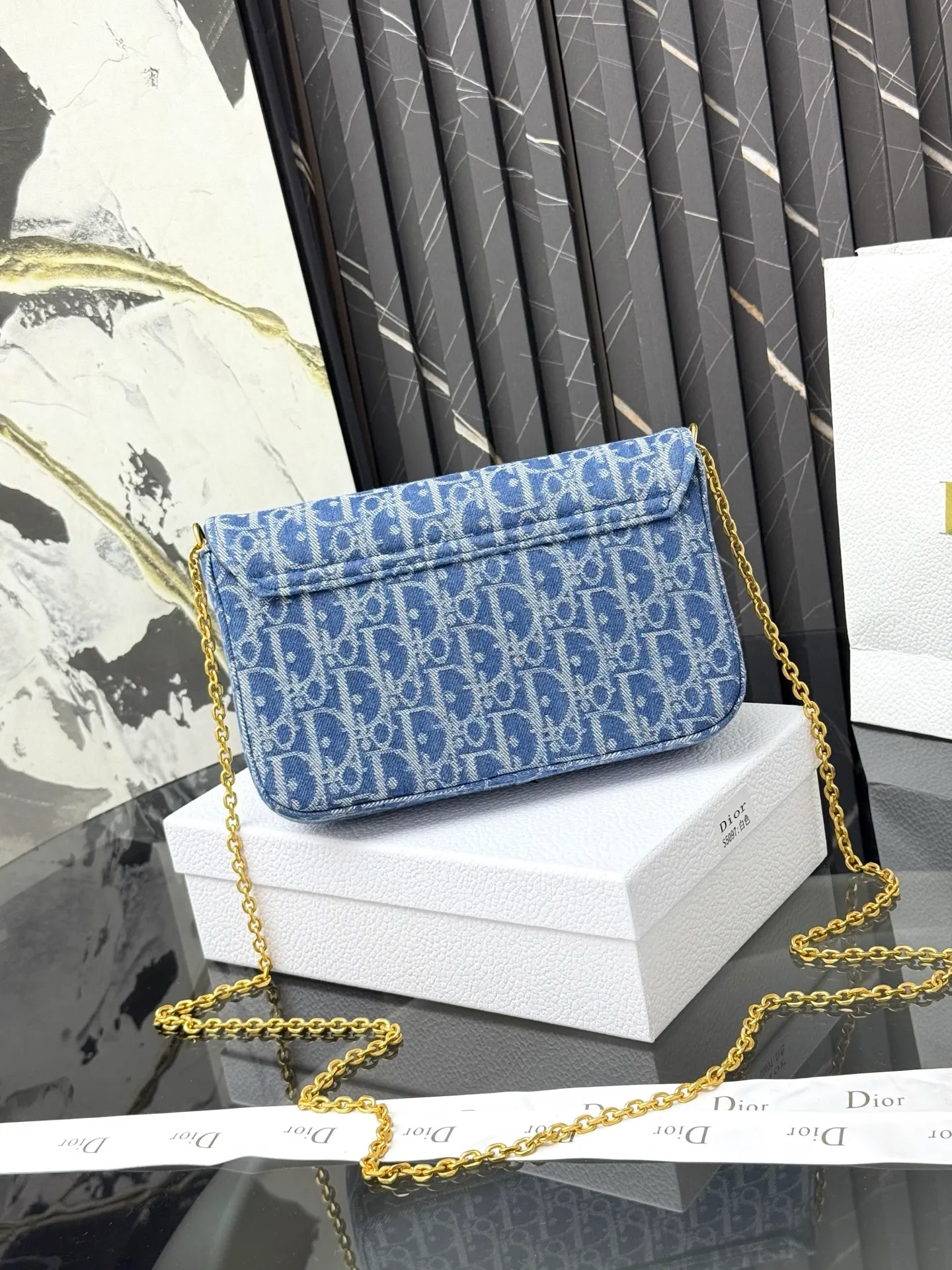 💰290💰 This saddle chain handbag has smooth and coordinated lines, making it a fashionable and practical item. Carefully crafted from blue Denim Dior Oblique jacquard fabric, the classic Dior pattern is reinterpreted with an irregular stonewash effect to highlight the fashionable style. It is paired with an asymmetric flap and a metal stirrup D-shaped pendant with antique gold finish. The spacious interior compartments can store a variety of daily essentials, and the chain makes it easy to carry on the shoulder or cross-body. Easily combines with other pieces from the saddle collection. Flap closure No.: S5907CTZQ_M928 Front stirrup D-shaped charm 1 compartment 6 card slots 1 slip pocket - No.: S5097 Dimensions: 21.5x12.5x3.7 cm (LxHxW) Can store 1 mobile phone, 1 card holder and lipstick Chain length: 118 cm Length from the top of the chain to the top of the bag: 57 cm