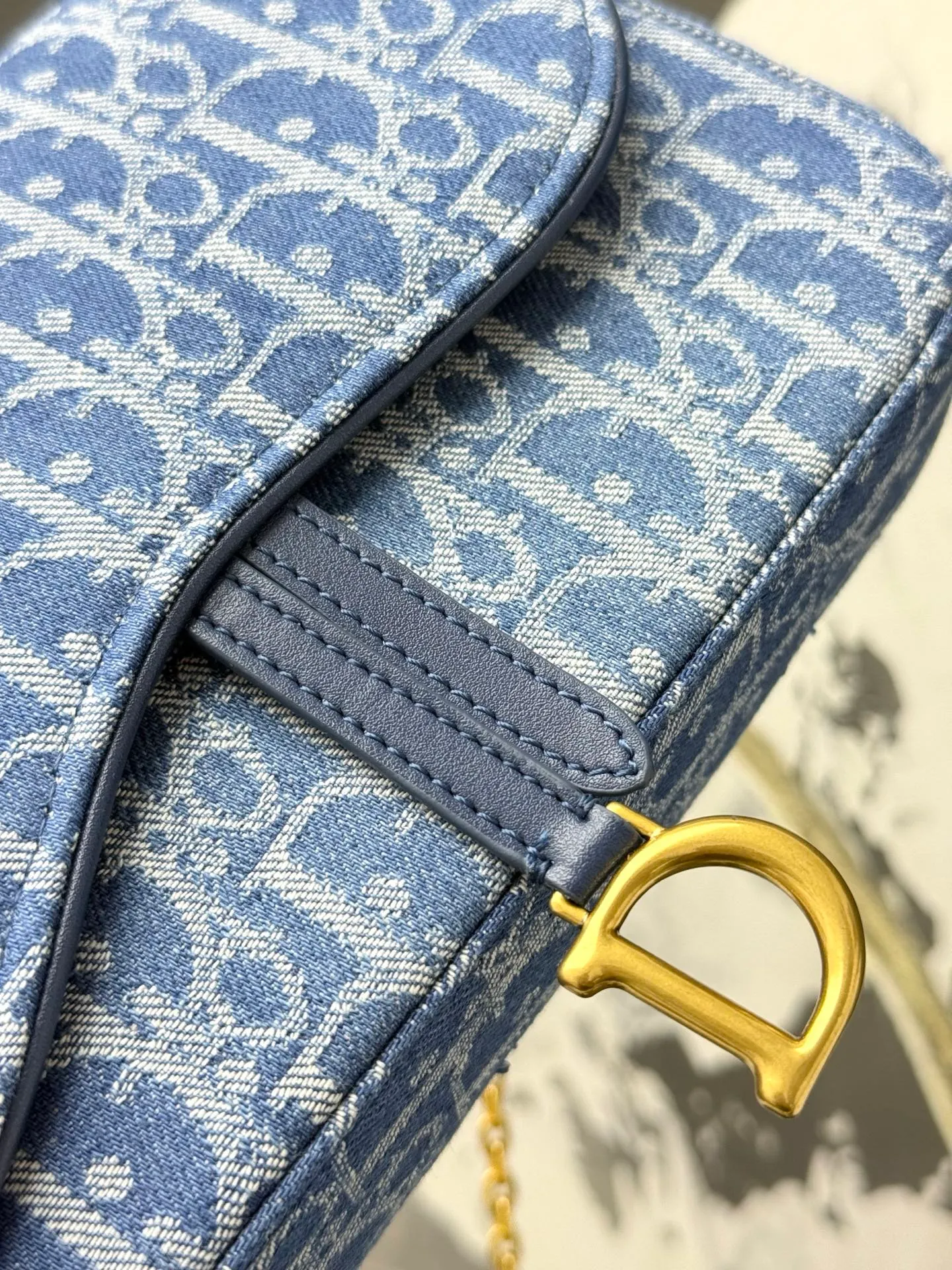💰290💰 This saddle chain handbag has smooth and coordinated lines, making it a fashionable and practical item. Carefully crafted from blue Denim Dior Oblique jacquard fabric, the classic Dior pattern is reinterpreted with an irregular stonewash effect to highlight the fashionable style. It is paired with an asymmetric flap and a metal stirrup D-shaped pendant with antique gold finish. The spacious interior compartments can store a variety of daily essentials, and the chain makes it easy to carry on the shoulder or cross-body. Easily combines with other pieces from the saddle collection. Flap closure No.: S5907CTZQ_M928 Front stirrup D-shaped charm 1 compartment 6 card slots 1 slip pocket - No.: S5097 Dimensions: 21.5x12.5x3.7 cm (LxHxW) Can store 1 mobile phone, 1 card holder and lipstick Chain length: 118 cm Length from the top of the chain to the top of the bag: 57 cm