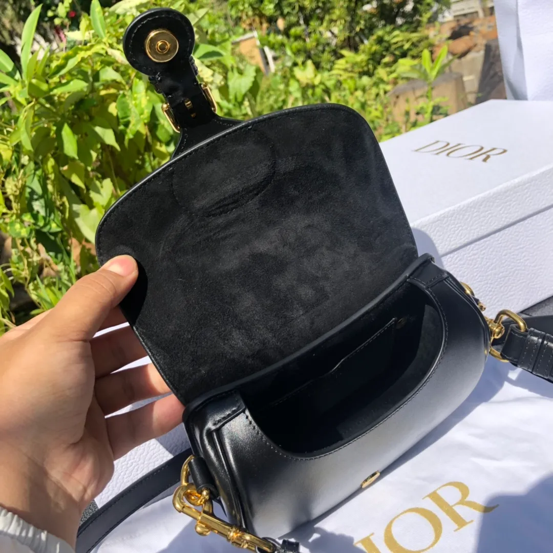 Top upgraded version 💰1700 Small size: 18×14×5cm Dior overseas channels! Dior Saddle Bag😘This Dior Bobby handbag is a shoulder bag style, showing elegant silhouette and coordinated proportions. This small bag is crafted from glossy black calfskin and accented with antiqued gold hardware for added style. The interior is designed with suede leather, which is soft and rich in texture. With a detachable and adjustable shoulder strap embellished with a military-style buckle, it can be worn on the shoulder, cross-body or handheld.
