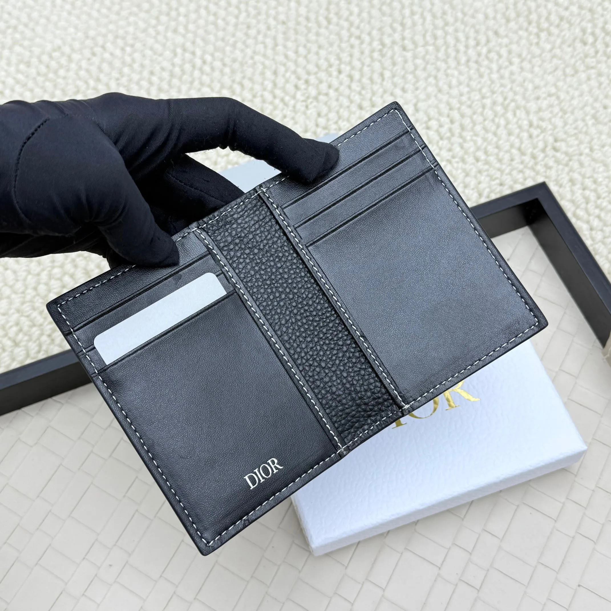 💰120💋Dior’s new bi-fold card holder is an elegant accessory that showcases Dior’s exquisite craftsmanship. Crafted from black inlaid grained calfskin, this card holder is detailed with beige and black Oblique print fabric details that accentuate the classic saddle silhouette. There are three card slots on each side and two compartments for storing bills and cash. Elegantly styled with a metal-clad brass Dior signature on the front, it fits easily into any pocket. Style number: H138 Size: 8.2*11.2cm