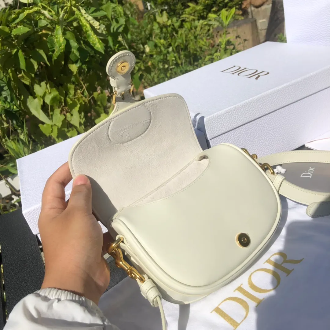 Top upgraded version 💰1700 Small size: 18×14×5cm Dior overseas channels! Dior Saddle Bag😘This Dior Bobby handbag is a shoulder bag style, showing elegant silhouette and coordinated proportions. This small bag is crafted from white glossy calfskin and accented with antiqued gold hardware for added style. The interior is designed with suede leather, which is soft and rich in texture. With a detachable and adjustable shoulder strap embellished with a military-style buckle, it can be worn on the shoulder, cross-body or handheld.