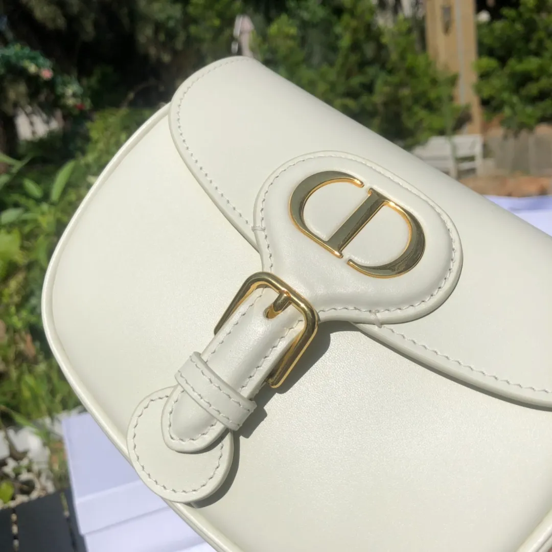 Top upgraded version 💰1700 Small size: 18×14×5cm Dior overseas channels! Dior Saddle Bag😘This Dior Bobby handbag is a shoulder bag style, showing elegant silhouette and coordinated proportions. This small bag is crafted from white glossy calfskin and accented with antiqued gold hardware for added style. The interior is designed with suede leather, which is soft and rich in texture. With a detachable and adjustable shoulder strap embellished with a military-style buckle, it can be worn on the shoulder, cross-body or handheld.