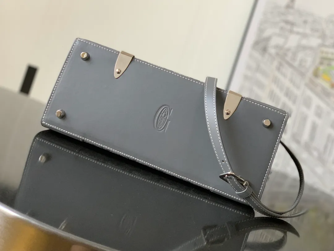 The P1700 original Saïgon bag is one of the signature pieces of the House of Goyard, embodying all the characteristic elements of the brand's boxmaking craftsmanship, such as wood, strips, leather corners and box-making nails. The Saigon Small Bag features a structured design and a removable shoulder strap for a chic and elegant look.  20 cm x 12 cm x 28 cm 🔎LAR 020186-Grey
