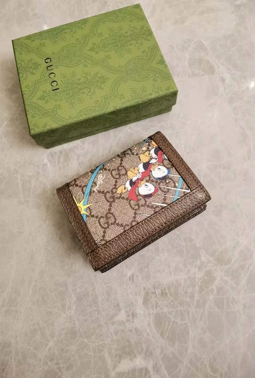 💰370 🇭🇺🇭🇺Epilogue original leather short wallet ~ Donald Duck series 🐥🐥The new pattern of Donald Duck and his three nephews appearing together adds an unconstrained charm to the classic Gucci bag. It is full of fun and fun for the family to fly to the stars 🐥🐥fashionable and practical! Style number: 648121, size: 11-8.5-3cm