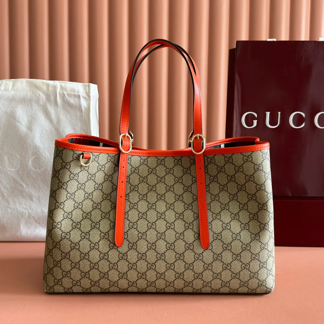 p980. 💋💋💋"With full set of original counter packaging" [New product] GG Emblem series reinterprets the brand's timeless elegance and exquisite craftsmanship. Inspired by the equestrian world, this tote bag features an adjustable top handle with numbered eyelets. New GG monogram coated fabric in beige and dark brown Orange leather trim with contrast stitching Light gold tone hardware Red and green webbing cotton lining The bag pictured is sold separately and does not come with the bag charm. Also features D-ring for hanging removable items Adjustable handle with numbered eyelets (height: 21.5 cm - 31.5 cm) Interior: two compartments and one central zipped compartment Magnetic snap closure Ident.: 815213. Dimensions: 38cm (width) x 25cm (height) x 15cm (depth) Weight: about 0.85kg Color: brown orange PVC/original leather. Made in Italy