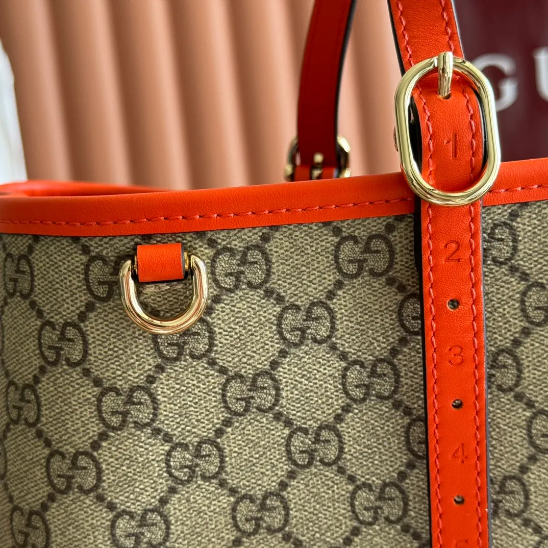 p980. 💋💋💋"With full set of original counter packaging" [New product] GG Emblem series reinterprets the brand's timeless elegance and exquisite craftsmanship. Inspired by the equestrian world, this tote bag features an adjustable top handle with numbered eyelets. New GG monogram coated fabric in beige and dark brown Orange leather trim with contrast stitching Light gold tone hardware Red and green webbing cotton lining The bag pictured is sold separately and does not come with the bag charm. Also features D-ring for hanging removable items Adjustable handle with numbered eyelets (height: 21.5 cm - 31.5 cm) Interior: two compartments and one central zipped compartment Magnetic snap closure Ident.: 815213. Dimensions: 38cm (width) x 25cm (height) x 15cm (depth) Weight: about 0.85kg Color: brown orange PVC/original leather. Made in Italy