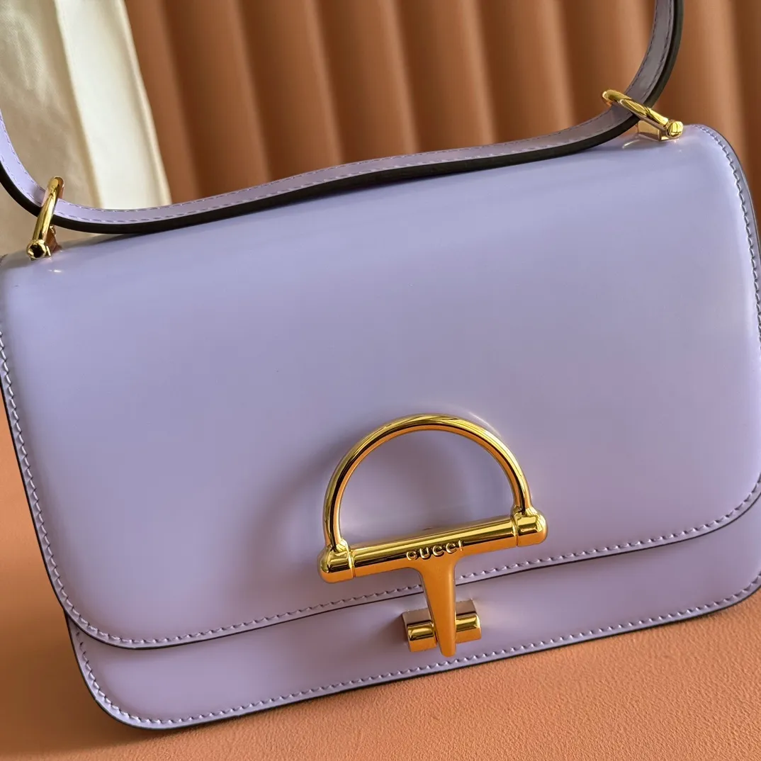 p1640. 💋💋💋【With full set of original counter packaging】2025 autumn and winter series, the Gucci Siena series small shoulder bag continues the evolution of the iconic element of Gucci's classic horsebit. Crafted from fine glossy leather, this shoulder bag has a structured shape and a half-horsebit buckle design from the 1970s. Finished with gold-tone hardware, the interior is lined with three levels of gusseting and a zipped pocket. Black fine glossy leather Gold-tone hardware Black leather lining Interior: 3-level fastening and 1 zipped pocket Shoulder straps: Height: 23cm – 25cm; Length: 127cm Half-horsebit snap fastener Ident: 846705. Dimensions: 22.5cm (width) x 14cm (height) x 8cm (depth) Weight: approx. 0.7kg Color: Purple full leather. Made in Italy