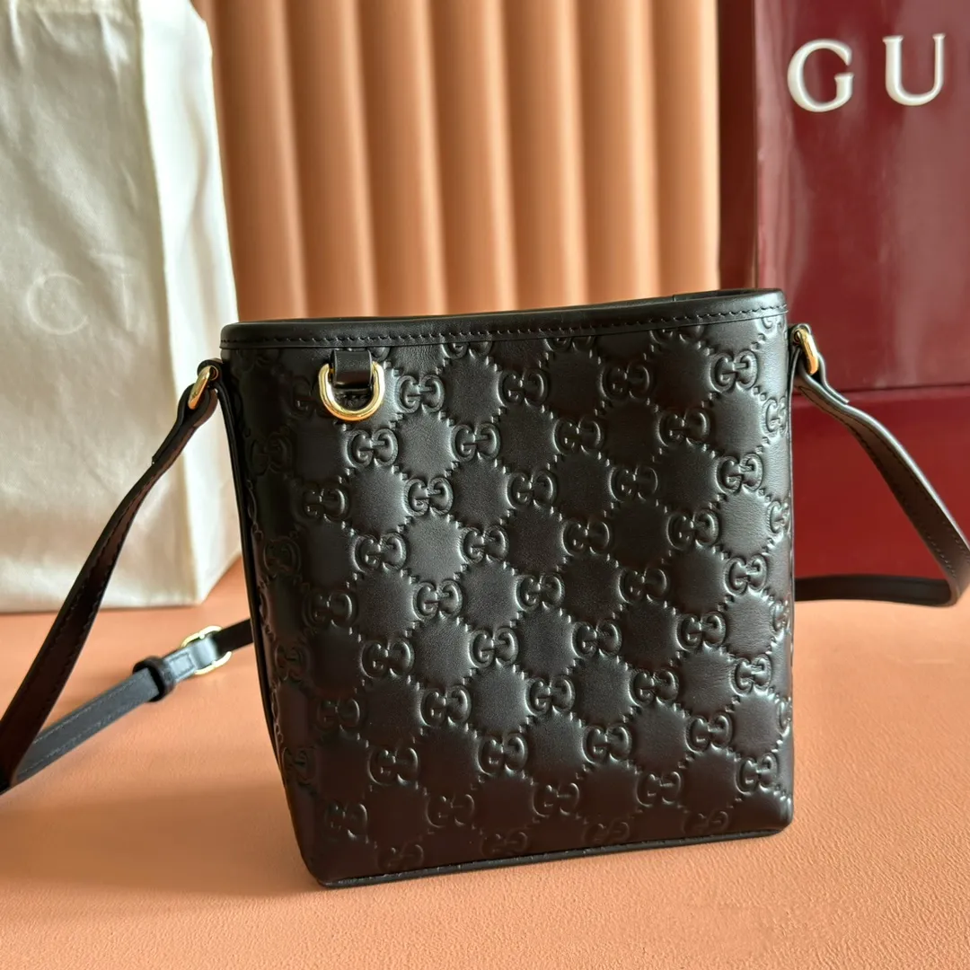 p960. 💋💋💋"With full set of original counter packaging" [New product] 2025 autumn and winter series, this mini bucket bag reinterprets brand elements with practical design, adding a masterpiece to the new GG Emblem series. This mini bucket bag has a simple and compact silhouette with exquisite details. It is designed with a long shoulder strap and is comfortable to carry, making it a versatile item suitable for day and night occasions. Black GG printed embossed leather Gold tone hardware Black cotton and linen lining The bag pictured is sold separately and does not come with the bag charm. Adjustable leather shoulder strap Height: 52-58 cm Model: 847090. Dimensions: 15 (18) cm (width) x 18 cm (height) x 8 cm (depth) Weight: approx. 0.211 kg Color: Black embossed. Made in Italy