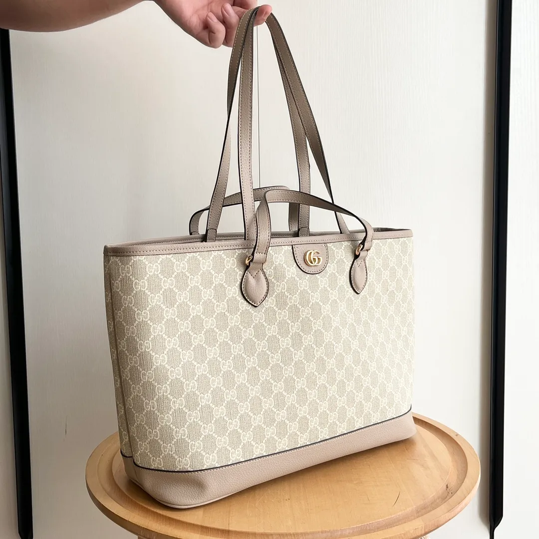 Actual shot #💰300 Model: 739730 Size: 38.5x28.5x15cm The GG Ophidia series is still one of Gucci’s iconic handbags. The brand launches new styles every season, creating versatile accessories that suit every look. Two handles give this tote a multi-functional character, allowing it to be worn as a shoulder bag or as a handbag. As a classic design element, the Double G has been deeply embedded in the brand's design. On this handbag, it is presented in a dazzling manner, contrasting with the GG Supreme canvas and brown leather piping.