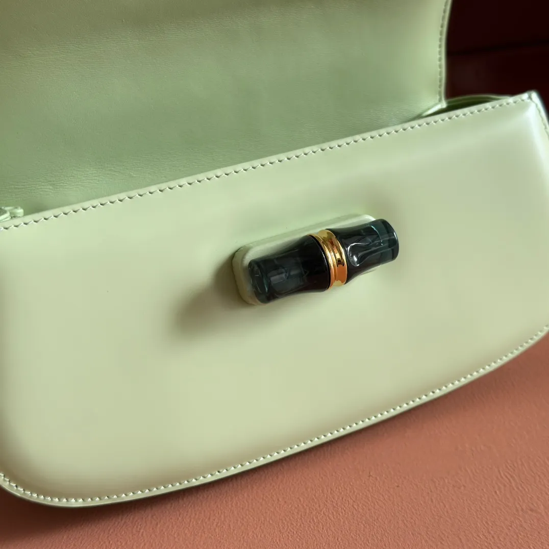 p1680. 💋💋💋 Equipped with full counter packaging [New Product] This small handbag reinterprets the iconic bamboo-shaped accessories with resin and brass details, adding another dazzling masterpiece to the 2025 spring and summer series. The Gucci Bamboo Diva tote adds a pop of color to any look. White glossy buffed leather Resin and brass bamboo hardware Three-level articulated compartments White leather lining Interior: One zippered pocket and a mirror with removable pocket Handle height 10cm Removable and adjustable leather shoulder strap (50cm high); length adjustable between 100cm and 116cm Bamboo lock Model number: 827750 Dimensions: 26.6cm (width) x 13cm (h) x 8 cm (depth) Weight: about 0.9 kg Color: green full leather/original leather. Made in Italy