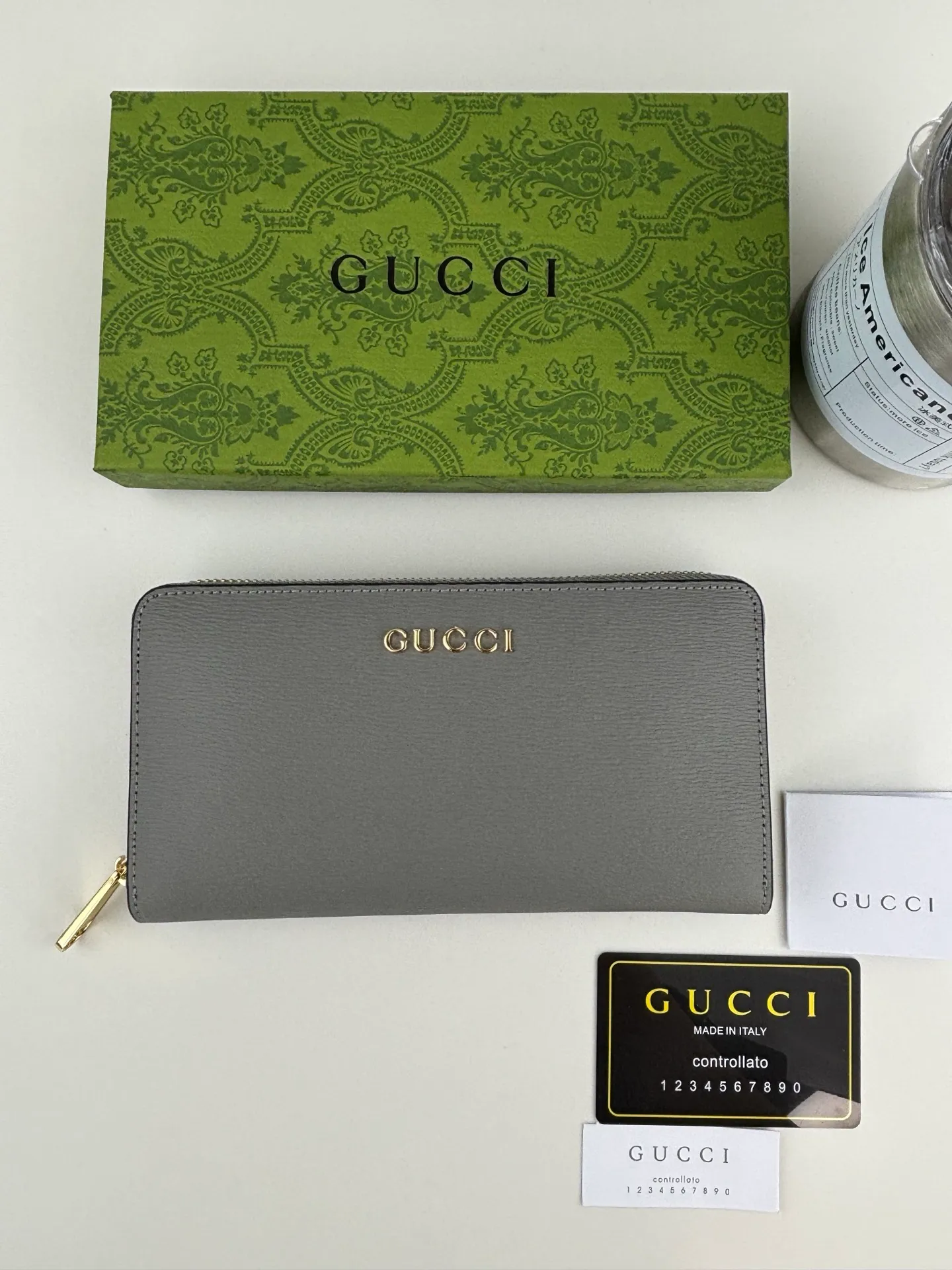 💰170 GUCCl Long zipper wallet with handwritten Gucci logo. Exploring self-expression with unlimited possibilities has become the spiritual connotation of brand design. Crafted from gray leather, this long clip is embellished with a gold-toned handwritten Gucci logo-shaped hardware, adding a touch of the brand's signature charm to the entire design. Gray leather, gold-tone hardware, taffeta lining, scripted Gucci logo detail. Interior: Six card compartments, two bill compartments, two separate internal compartments and a zippered coin pocket, this classic piece features a zipper closure Style number: 772642 Dimensions: 19cm x 10cm x 3.5cm Colour: Gray