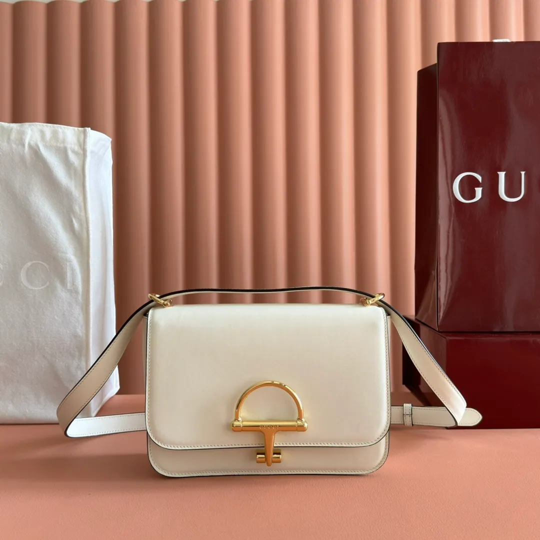 p1640. 💋💋💋【With full set of original counter packaging】2025 autumn and winter series, the Gucci Siena series small shoulder bag continues the evolution of the iconic element of Gucci's classic horsebit. Crafted from fine glossy leather, this shoulder bag has a structured shape and a half-horsebit buckle design from the 1970s. Finished with gold-tone hardware, the interior is lined with three levels of gusseting and a zipped pocket. Black fine glossy leather Gold-tone hardware Black leather lining Interior: 3-level fastening and 1 zipped pocket Shoulder straps: Height: 23cm – 25cm; Length: 127cm Half-horsebit snap fastener Ident: 846705. Dimensions: 22.5cm (width) x 14cm (height) x 8cm (depth) Weight: approx. 0.7kg Color: White full leather. Made in Italy