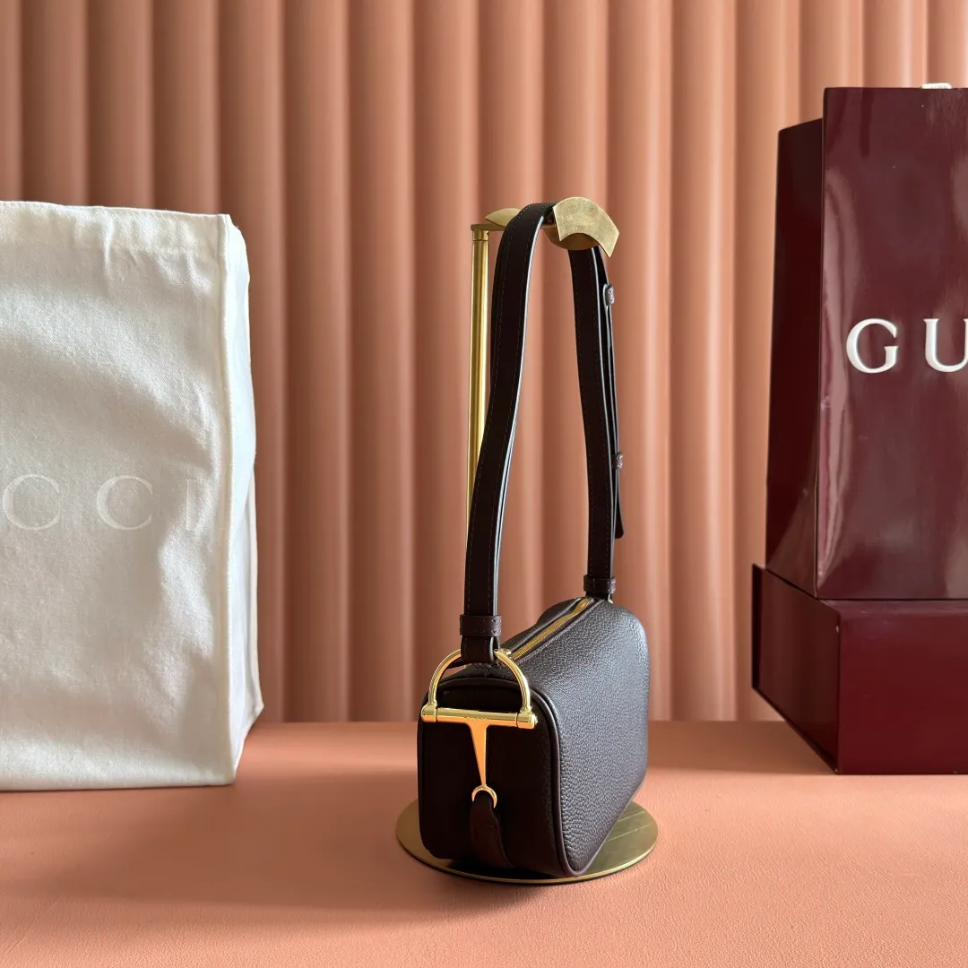 p1060💋💋💋【With full set of original counter packaging】The brand interprets iconic elements from a contemporary perspective and re-presents the Gucci half-horse bit design. It uses soft cow leather that fits the body shape to inject new style into classic accessories. This mini bag is crafted from soft grained leather and features a half horsebit detail on the side. Green grained soft leather. Light gold tone hardware. Tonal cotton and linen blend lining. Half horsebit buckle. Calf leather shoulder strap (23cm high). Zip closure. Ident.: 860784. Dimensions: 19cm (width) x 19.5cm (height) x 9cm (depth) Weight: approximately 272g Color: brown/full leather.