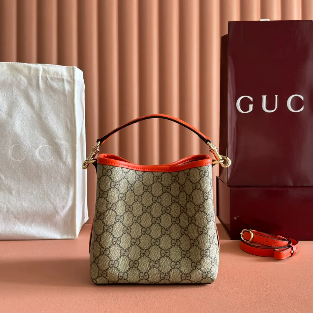 p920. 💋💋💋"With full set of original counter packaging" [New product] GG Emblem series reinterprets the brand's timeless elegance and exquisite craftsmanship. This bucket bag is lined in webbed cotton and features an internal compartment for added functionality. New GG monogram coated fabric in beige and dark brown Orange leather piping Light gold tone hardware Red and green web cotton lining The bag pictured is sold separately and does not come with the bag charm. Top handle with hook closure (height: 14 cm) Additional D-ring for attaching removable items Interior: two compartments and a central snap-stud compartment Removable and adjustable leather shoulder strap (height: 52 cm - 57.5 cm; length: 107 cm - 114 cm) Magnetic snap closure Ident.: 815118. Dimensions: 19 cm (width) x 18 cm (height) x 11 cm (depth) Weight: about 0.45 kg Color: brown orange pvc/original leather. Made in Italy