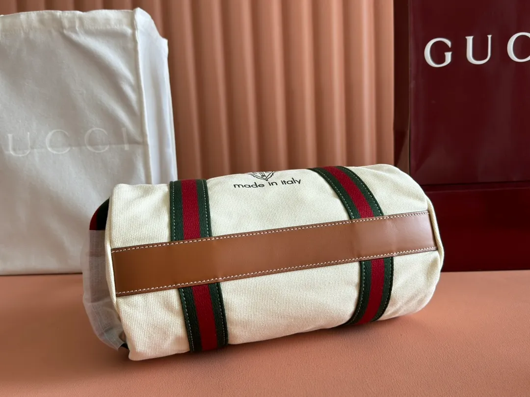 p960. 💋💋💋"With full set of original counter packaging"💕[New Product] With the theme of freedom, vitality and community, the 2025 spring and summer series newly presents a variety of travel items and men's bags, adding more fun to travel and exploration. This canvas travel bag features embellished stitching at the top, blue leather piping and a 'Gucci Made in Italy' badge printed on the front. Dark blue canvas Dark blue leather trimming "Gucci Made in Italy" and badge print Red and green webbing Top stitching detail Interior: 1 side handle Handle height: 12.5cm Adjustable webbing and canvas shoulder strap (55cm height); length adjustable from 77cm to 136cm Zip closure Ident.: 816865. Dimensions: 30cm (W) x 16cm (H) x 15cm (D) Weight: Approx. 0.54kg Color: White canvas. Made in Italy
