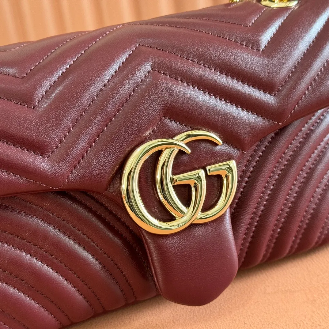 p1360. 💋💋💋【Full set of packaging at the counter】Imported original sheepskin pure copper hardware brand's iconic GG Marmont series is ingeniously integrated with double G styling accessories and faceted chain straps, and soft leather is selected to create a bag with soft lines. Simple and neat back pockets make medium and large bags more practical. Black V-shaped Matelassé sheepskin Light gold-tone hardware Gucci ankara red viscose lining Double G Interior: One zipped pocket External: One open pocket Sliding chain strap that can be used as a shoulder strap (56 cm high) Spring-buckle flap Ident: 837267. Dimensions: 26 cm (width) x 15 cm (height) x 7 cm (depth) Weight: approximately 0.65 kg Color: Encore red full leather/original leather. Made in Italy