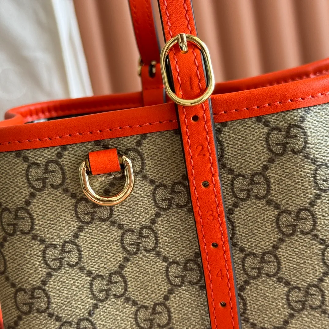 p960. 💋💋💋"With full set of original counter packaging" [New product] GG Emblem series reinterprets the brand's timeless elegance and exquisite craftsmanship. Inspired by the equestrian world, this tote bag features an adjustable top handle with numbered eyelets. Beige and dark brown GG monogram coated fabric Orange leather trim with contrasting stitching Light gold tone hardware Red and green webbing cotton lining The bag pictured is sold separately and does not come with the bag charm. Also features D-ring for attaching removable items Adjustable handle with numbered eyelets (height: 18cm - 28cm) Interior: two compartments and a central zippered compartment Adjustable leather shoulder strap (height: 51.5cm - 57cm; length: 104cm - 114cm) Magnetic snap closure Ident No.: 815214. Dimensions: 30cm (width) x 18cm (height) x 11cm (depth) Weight: approx. 0.8kg Color: Brown Orange/PVC. Made in Italy