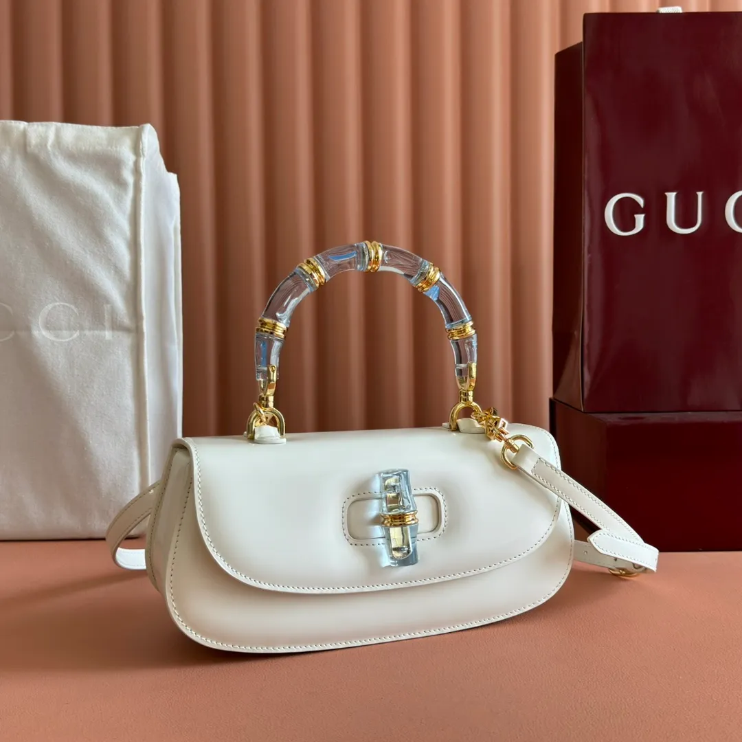 p1680. 💋💋💋 Equipped with full counter packaging [New Product] This small handbag reinterprets the iconic bamboo-shaped accessories with resin and brass details, adding another dazzling masterpiece to the 2025 spring and summer series. The Gucci Bamboo Diva tote adds a pop of color to any look. White glossy buffed leather Resin and brass bamboo hardware Three-level articulated compartments White leather lining Interior: One zippered pocket and a mirror with removable pocket Handle height 10cm Removable and adjustable leather shoulder strap (50cm high); length adjustable between 100cm and 116cm Bamboo lock Model number: 827750 Dimensions: 26.6cm (width) x 13cm (h) x 8 cm (depth) Weight: about 0.9 kg Color: white full leather/original leather. Made in Italy