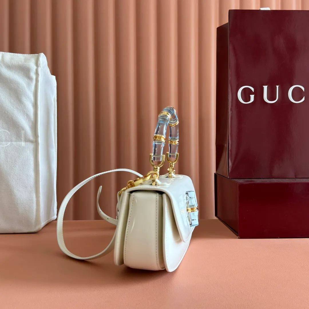 p1680. 💋💋💋 Equipped with full counter packaging [New Product] This small handbag reinterprets the iconic bamboo-shaped accessories with resin and brass details, adding another dazzling masterpiece to the 2025 spring and summer series. The Gucci Bamboo Diva tote adds a pop of color to any look. White glossy buffed leather Resin and brass bamboo hardware Three-level articulated compartments White leather lining Interior: One zippered pocket and a mirror with removable pocket Handle height 10cm Removable and adjustable leather shoulder strap (50cm high); length adjustable between 100cm and 116cm Bamboo lock Model number: 827750 Dimensions: 26.6cm (width) x 13cm (h) x 8 cm (depth) Weight: about 0.9 kg Color: white full leather/original leather. Made in Italy