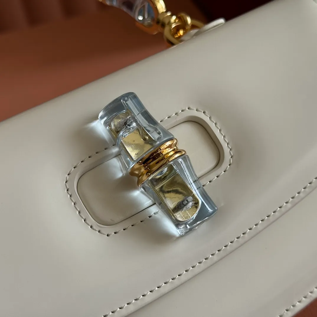 p1680. 💋💋💋 Equipped with full counter packaging [New Product] This small handbag reinterprets the iconic bamboo-shaped accessories with resin and brass details, adding another dazzling masterpiece to the 2025 spring and summer series. The Gucci Bamboo Diva tote adds a pop of color to any look. White glossy buffed leather Resin and brass bamboo hardware Three-level articulated compartments White leather lining Interior: One zippered pocket and a mirror with removable pocket Handle height 10cm Removable and adjustable leather shoulder strap (50cm high); length adjustable between 100cm and 116cm Bamboo lock Model number: 827750 Dimensions: 26.6cm (width) x 13cm (h) x 8 cm (depth) Weight: about 0.9 kg Color: white full leather/original leather. Made in Italy
