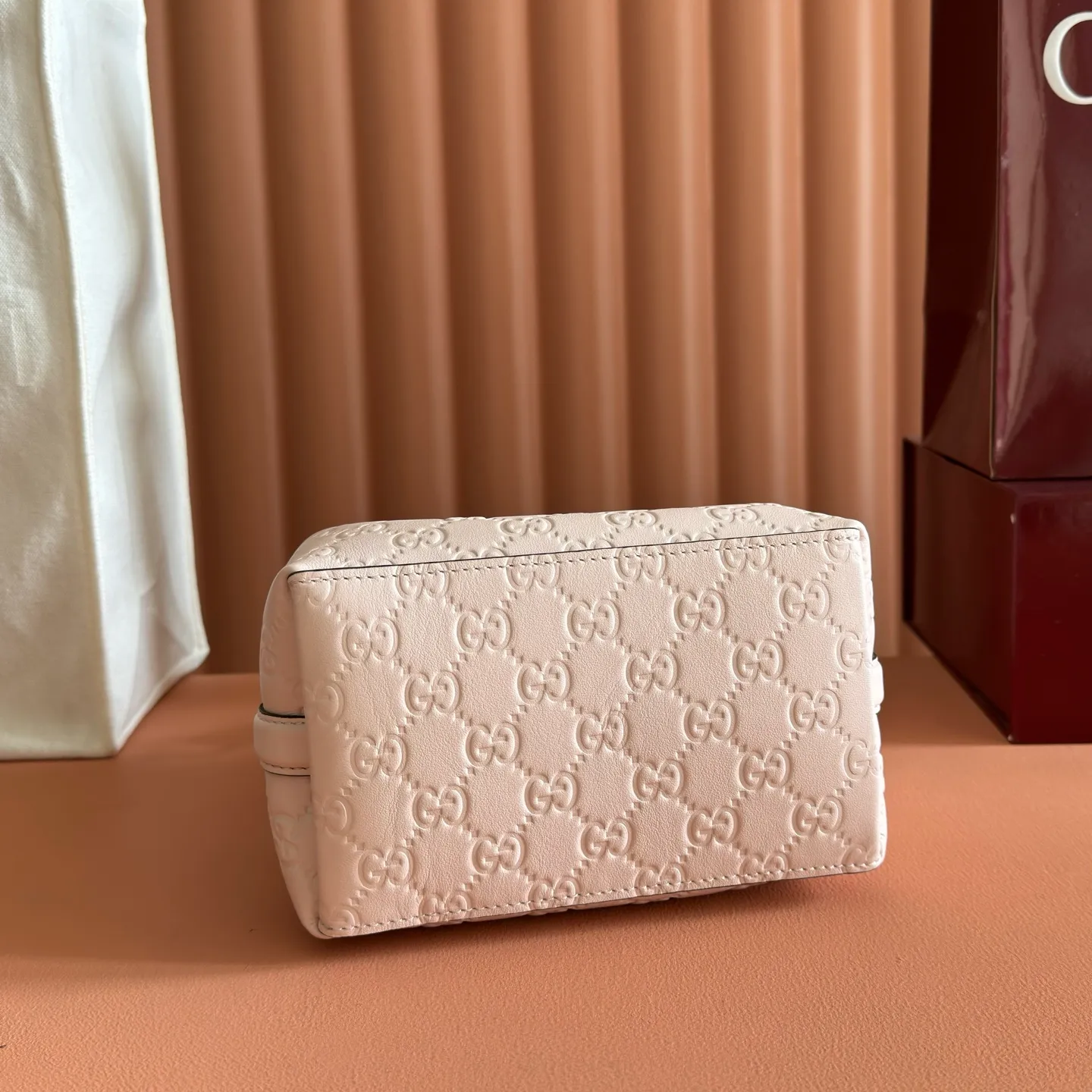 p1140. 💋💋💋【With full set of original counter packaging】GG Emblem series reinterprets the brand's timeless elegance and exquisite craftsmanship. Lined in webbed cotton, this bucket bag features an internal compartment for added functionality. Apricot pink GG printed embossed calf leather Light gold tone hardware Taupe cotton and linen lining Additional D-ring for attaching removable items Interior: two compartments and a central snap compartment Top handle with hook closure (height: 14 cm) Removable and adjustable calf leather shoulder strap (height: 52 cm - 57.5 cm; length: 107 cm - 114 cm) Magnetic snap closure Ident No.: 815118. Dimensions: 19cm (W) x 18cm (H) x 11cm (D) Weight: Approx. 0.45kg Color: Apricot Pink/Embossed. Made in Italy