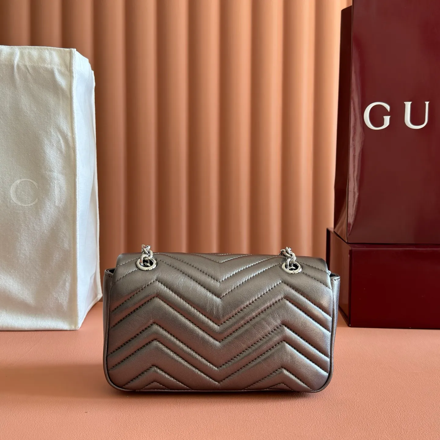 p1120💋💋💋【With full set of original counter packaging】The brand's iconic GG Marmont series is ingeniously integrated with double G styling accessories, faceted chain straps and soft silhouettes, and is made of gold and silver thread leather to create a shoulder bag style. Silver metallic quilted V-shaped lamé leather Silver-toned hardware Silver viscose lining Double G Interior: One open pocket Sliding chain strap that can be used as a shoulder strap (55 cm high) Spring-buckle flap Ref.: 837280. Dimensions: 22cm (W) x 12.5cm (H) x 6cm (D) Weight: approx. 0.55kg Colour: Gunmetal sheepskin Made in Italy