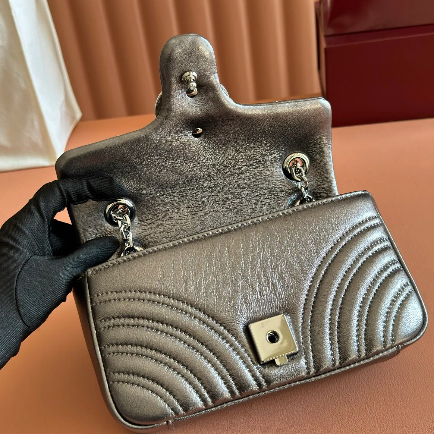 p1120💋💋💋【With full set of original counter packaging】The brand's iconic GG Marmont series is ingeniously integrated with double G styling accessories, faceted chain straps and soft silhouettes, and is made of gold and silver thread leather to create a shoulder bag style. Silver metallic quilted V-shaped lamé leather Silver-toned hardware Silver viscose lining Double G Interior: One open pocket Sliding chain strap that can be used as a shoulder strap (55 cm high) Spring-buckle flap Ref.: 837280. Dimensions: 22cm (W) x 12.5cm (H) x 6cm (D) Weight: approx. 0.55kg Colour: Gunmetal sheepskin Made in Italy