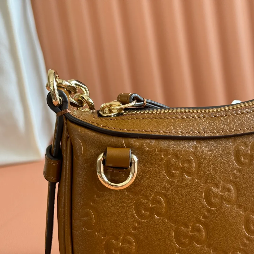 p900. 💋💋💋《With full set of original factory counter packaging》‼ ️【New Product】2025 Autumn and Winter Series, this small shoulder bag adopts a round silhouette with gold-tone accessories and chain straps, highlighting the style of the GG Emblem series. It features a zipper closure, an interior card pocket, and a cotton and linen lining for a refined feel. Gucci black (Rosso Ancora) GG printed embossed calf leather Gold tone accessories Gucci black (Rosso Ancora) cotton and linen lining The bag pictured is sold separately and does not come with the bag charm. Interior: card pocket, chain shoulder strap (23cm high), zipper closure. Model number: 847091. Dimensions: 19cm (bottom width) x 16.5cm (top width) 12cm (height) x 4cm (bottom depth) x 2.5cm (top depth) Weight: Approx. 0.211kg Color: Brown/Embossed. Made in Italy