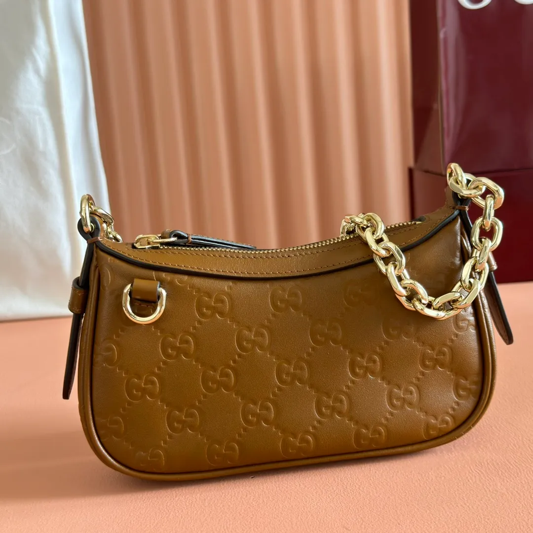 p900. 💋💋💋《With full set of original factory counter packaging》‼ ️【New Product】2025 Autumn and Winter Series, this small shoulder bag adopts a round silhouette with gold-tone accessories and chain straps, highlighting the style of the GG Emblem series. It features a zipper closure, an interior card pocket, and a cotton and linen lining for a refined feel. Gucci black (Rosso Ancora) GG printed embossed calf leather Gold tone accessories Gucci black (Rosso Ancora) cotton and linen lining The bag pictured is sold separately and does not come with the bag charm. Interior: card pocket, chain shoulder strap (23cm high), zipper closure. Model number: 847091. Dimensions: 19cm (bottom width) x 16.5cm (top width) 12cm (height) x 4cm (bottom depth) x 2.5cm (top depth) Weight: Approx. 0.211kg Color: Brown/Embossed. Made in Italy